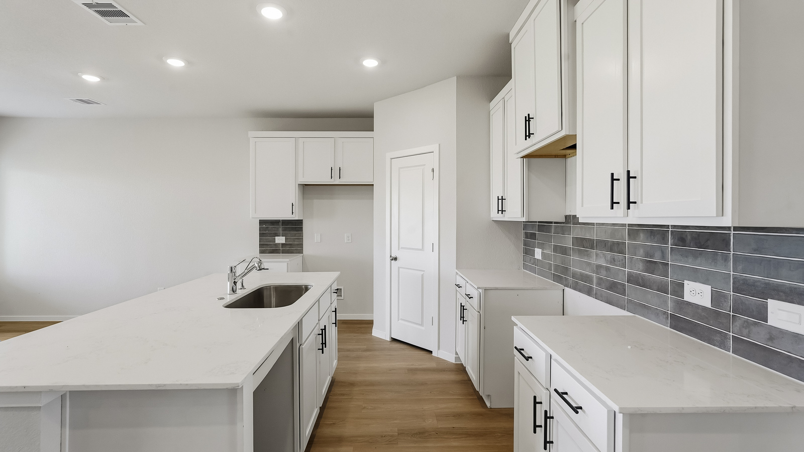 Kitchen with quartz countertops and an island and vinyl floor