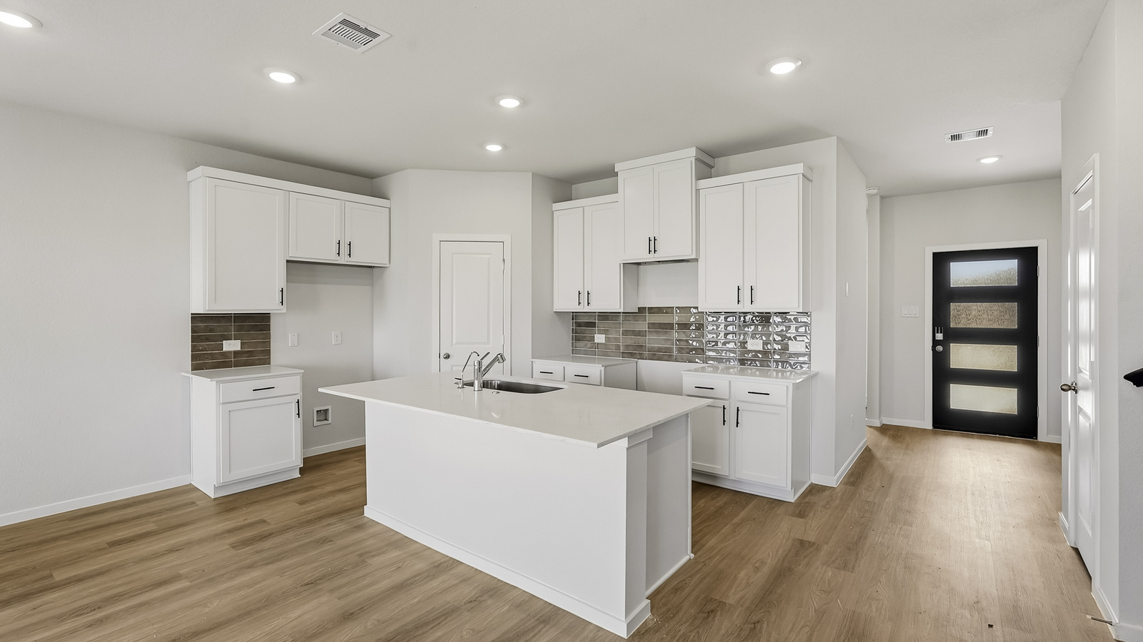 Kitchen with quartz countertops and an island and vinyl floor