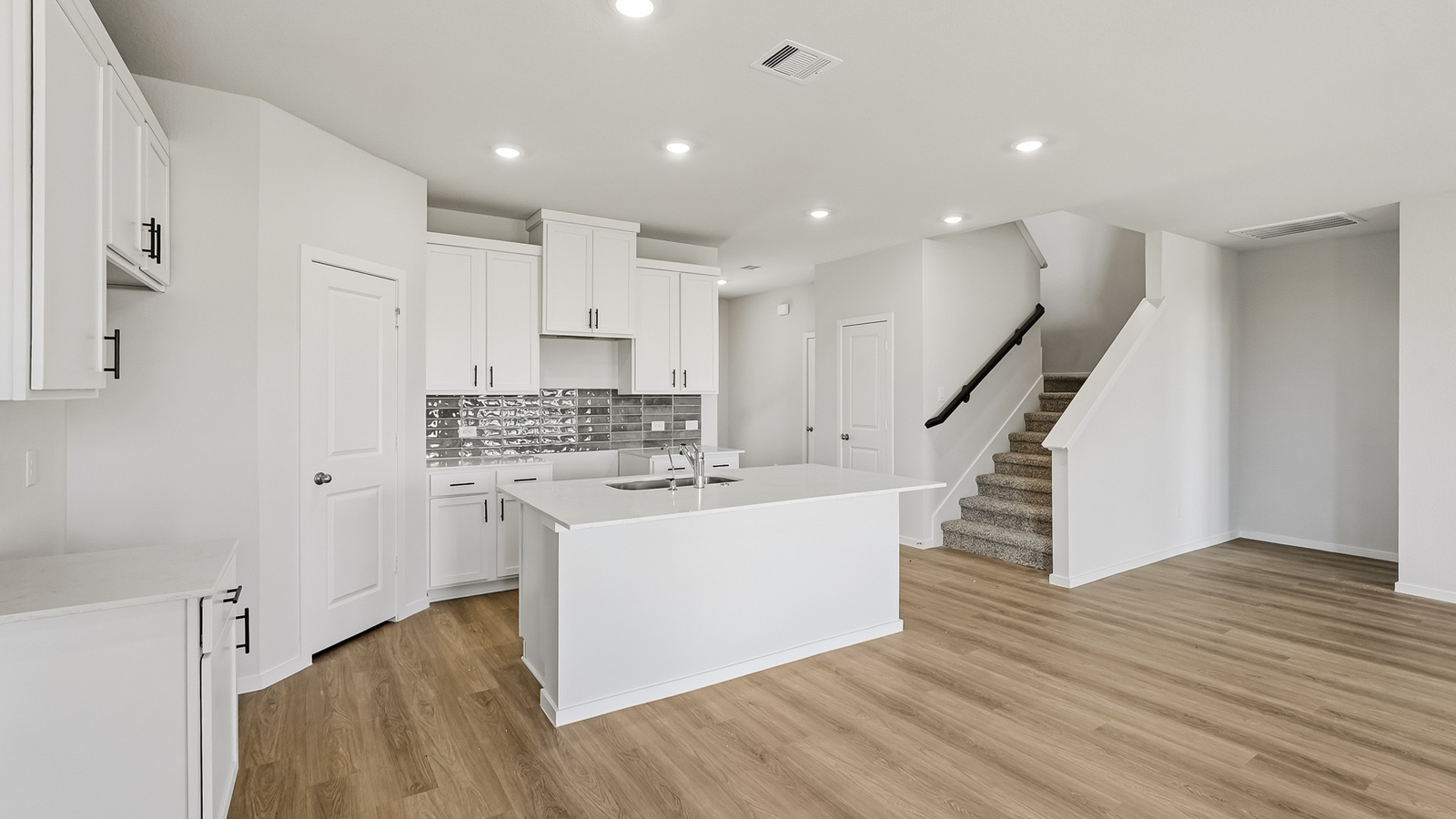 Kitchen with quartz countertops and an island and vinyl floor