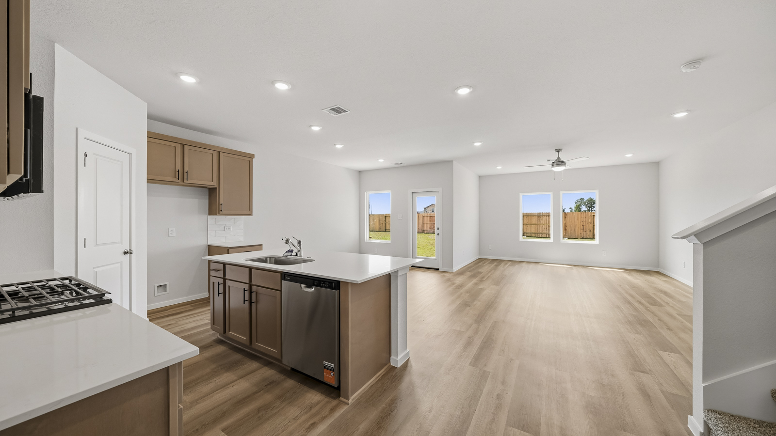 open concept living and dining area with vinyl flooring, arge windows, and quartz countertops in Brookshire, Tx
