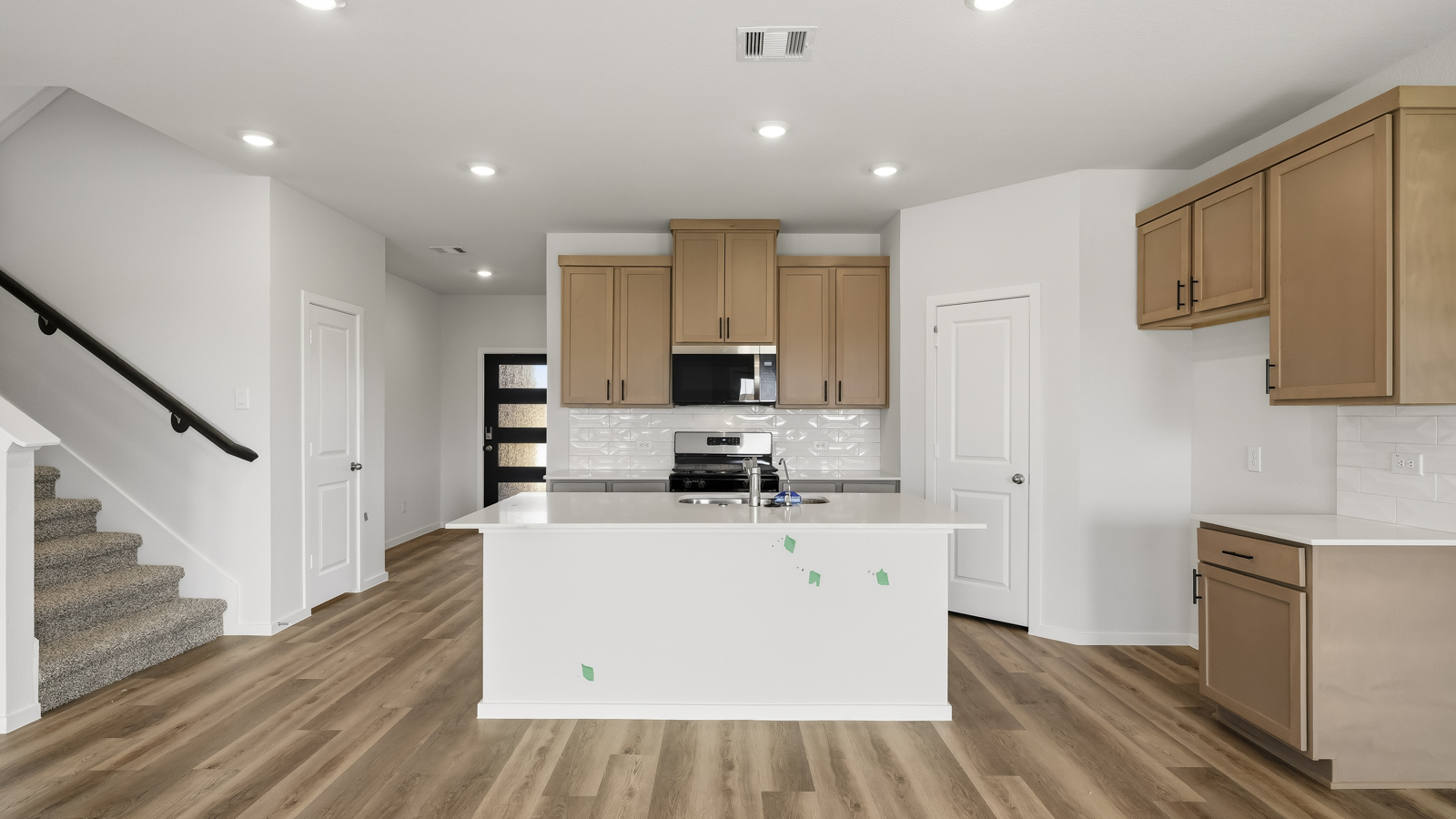 open concept living and dining area with vinyl flooring, arge windows, and quartz countertops in Brookshire, Tx