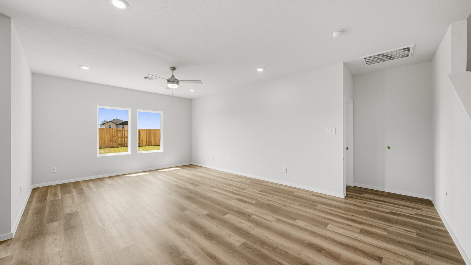 open concept living and dining area with vinyl flooring, arge windows, and quartz countertops in Brookshire, Tx