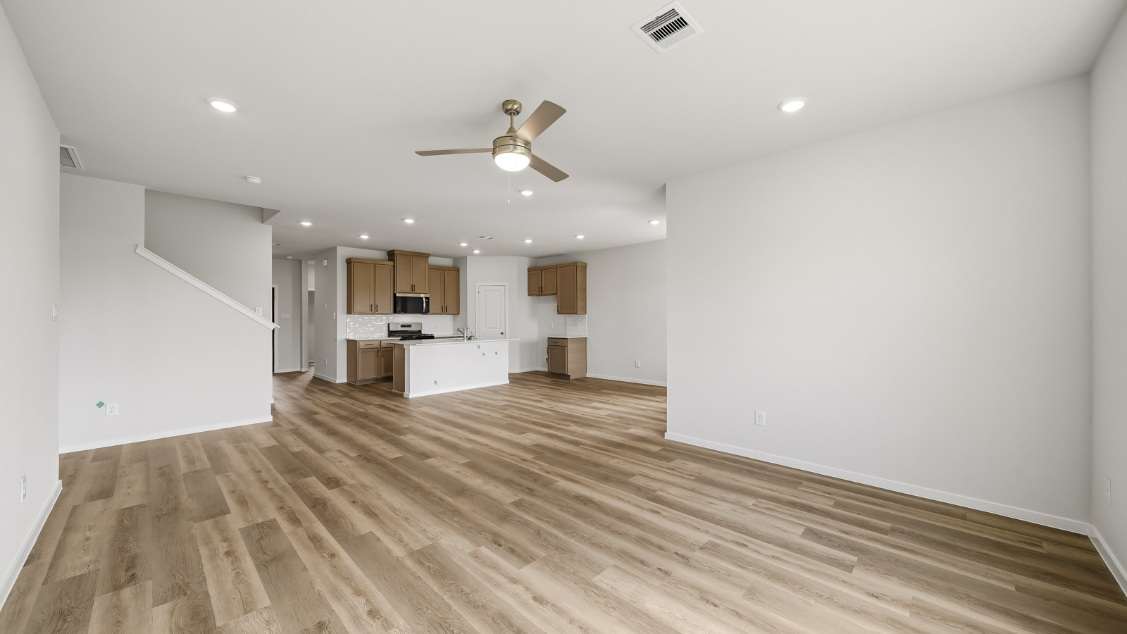 open concept living and dining area with vinyl flooring, arge windows, and quartz countertops in Brookshire, Tx