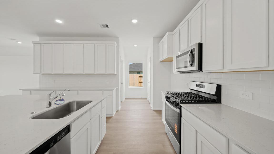 kitchen with quartz countertops, stainless steel appliances, and vinyl flooring