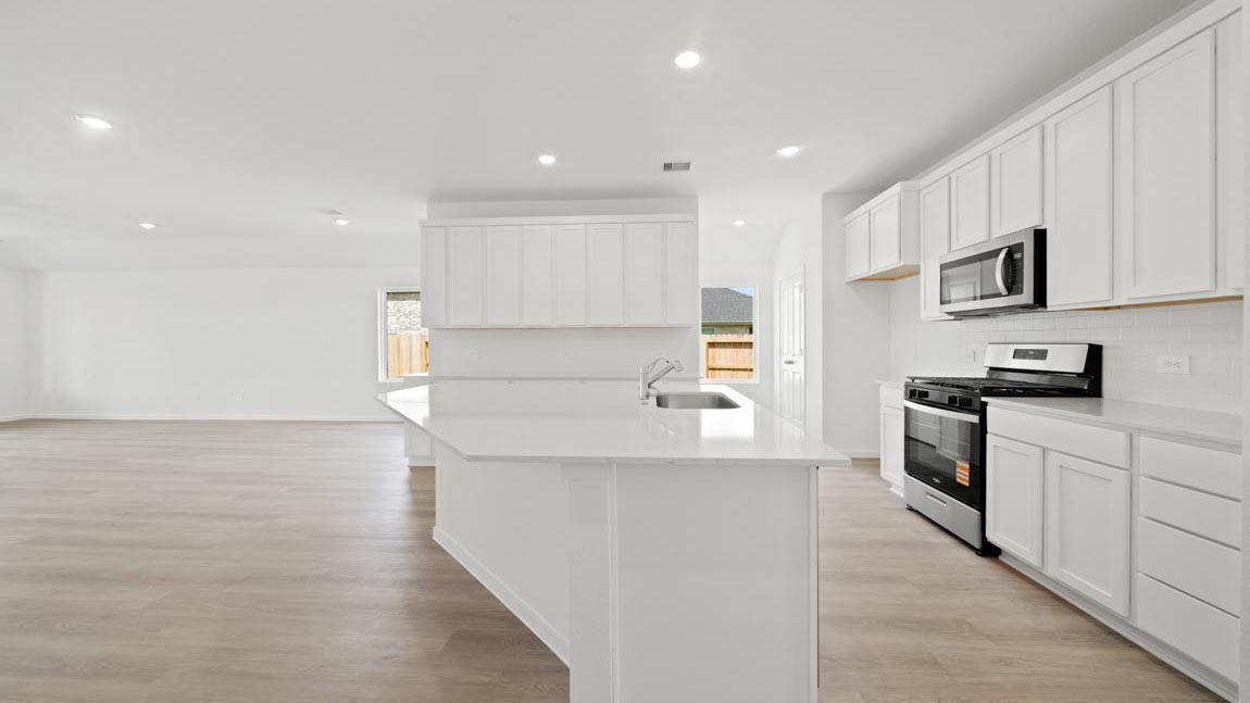 kitchen with quartz countertops, stainless steel appliances, and vinyl flooring