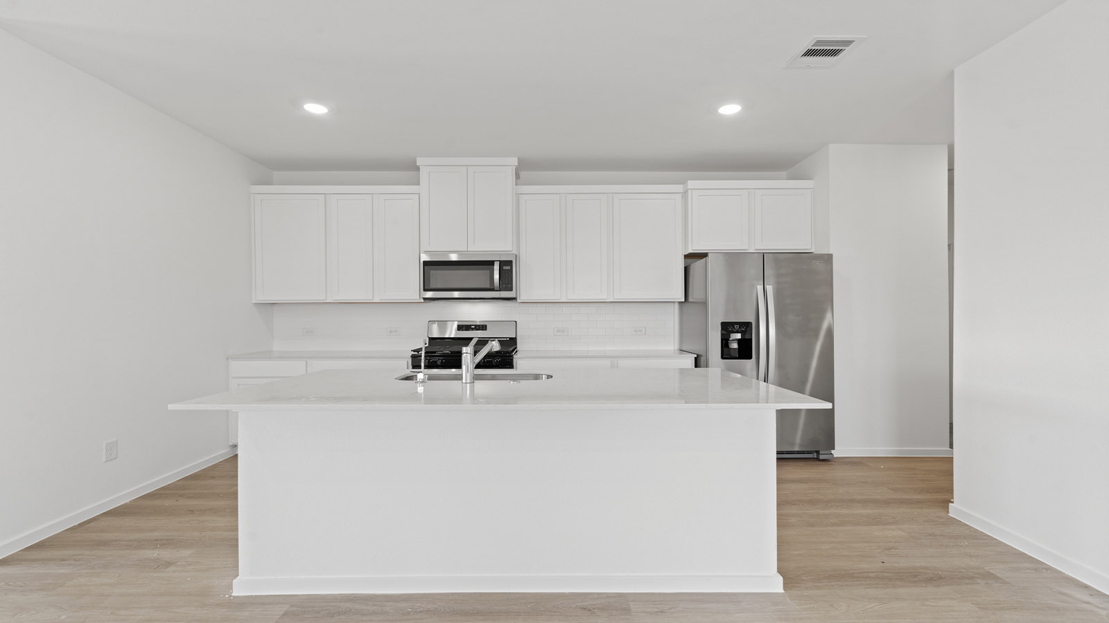 open concept livving and dining area with vinyl flooring, large windows, and quartz countertops