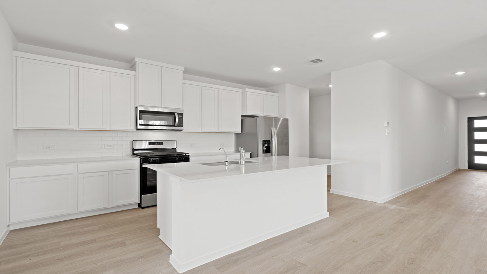 open concept livving and dining area with vinyl flooring, large windows, and quartz countertops