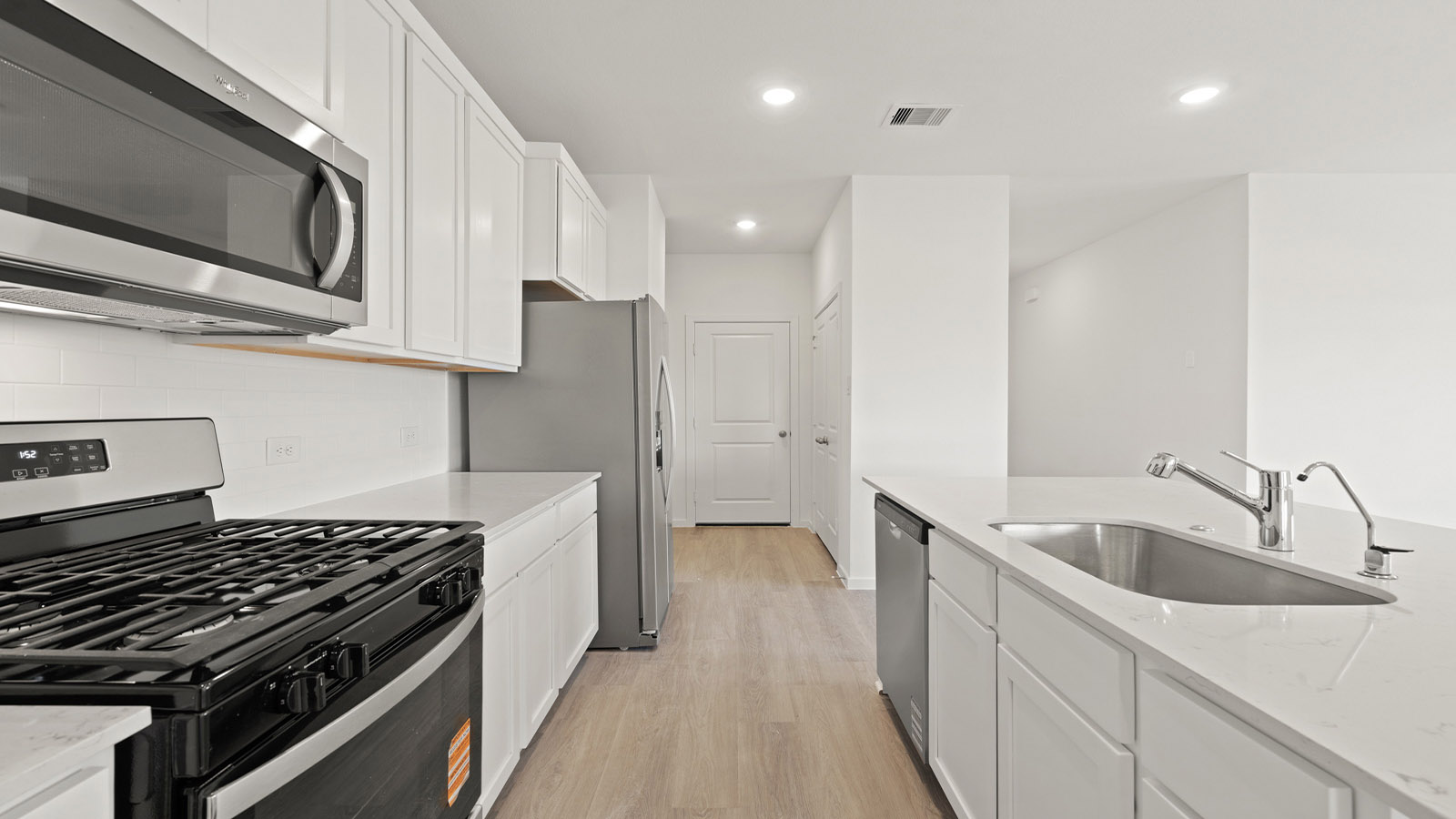 open concept livving and dining area with vinyl flooring, large windows, and quartz countertops