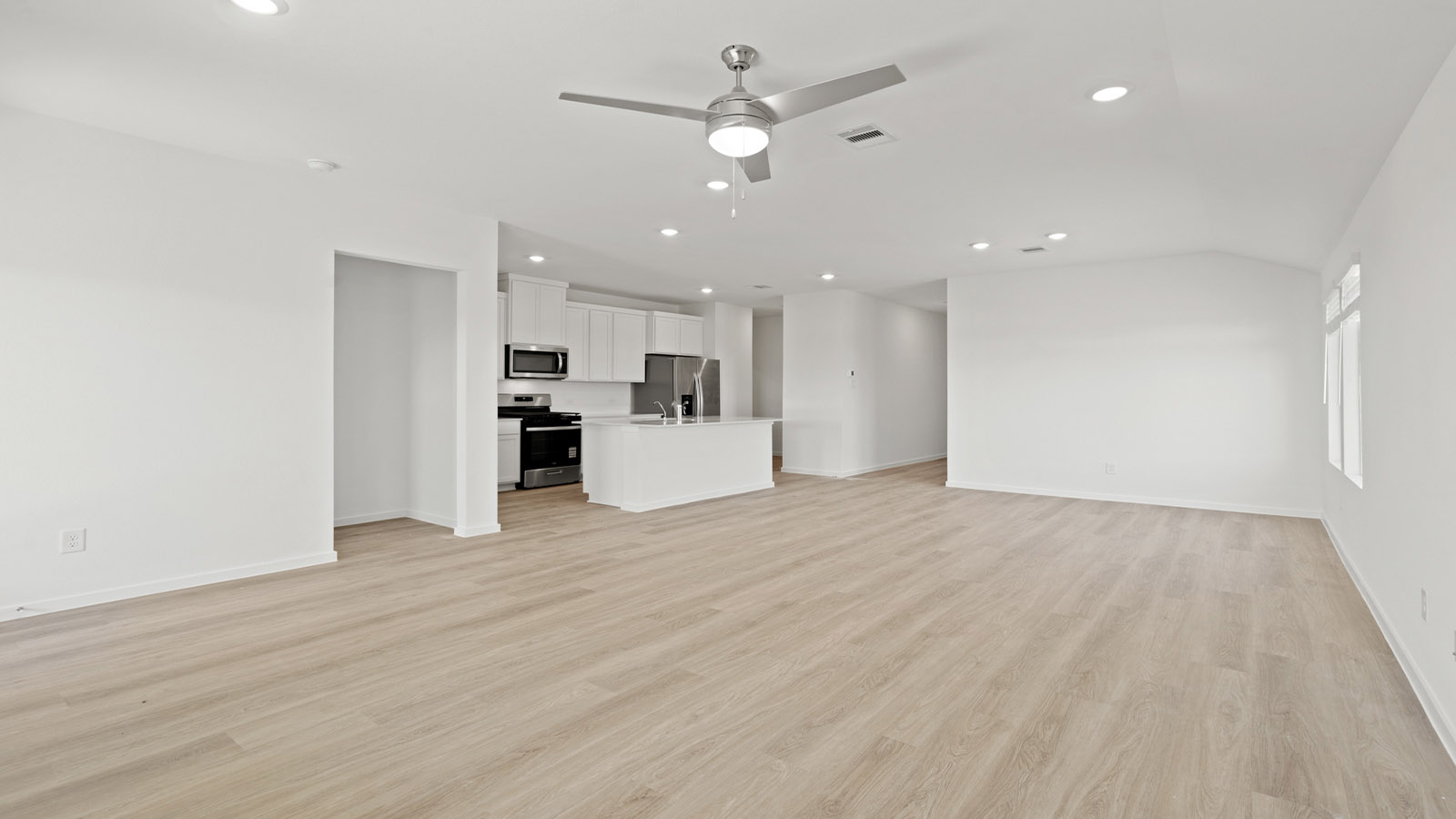 open concept livving and dining area with vinyl flooring, large windows, and quartz countertops