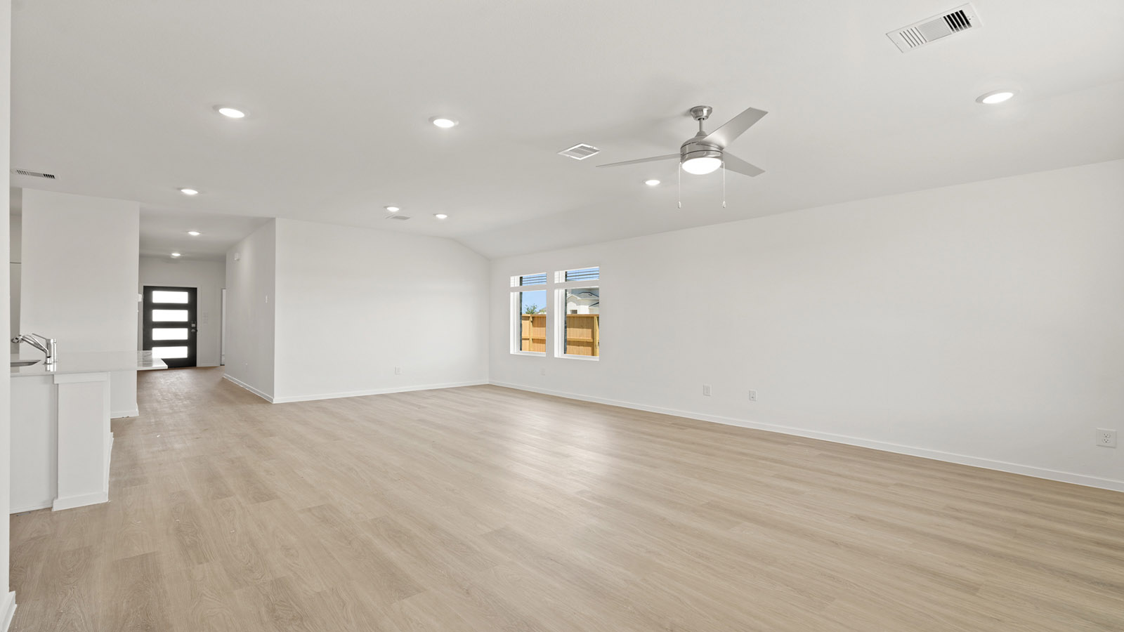 open concept livving and dining area with vinyl flooring, large windows, and quartz countertops