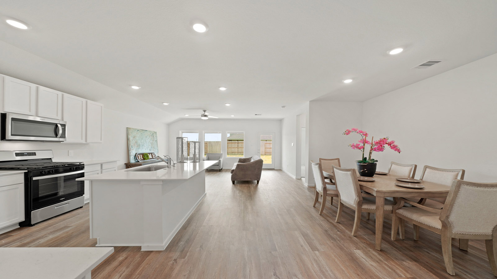 open concept living and dining area with vinyl flooring and large windows