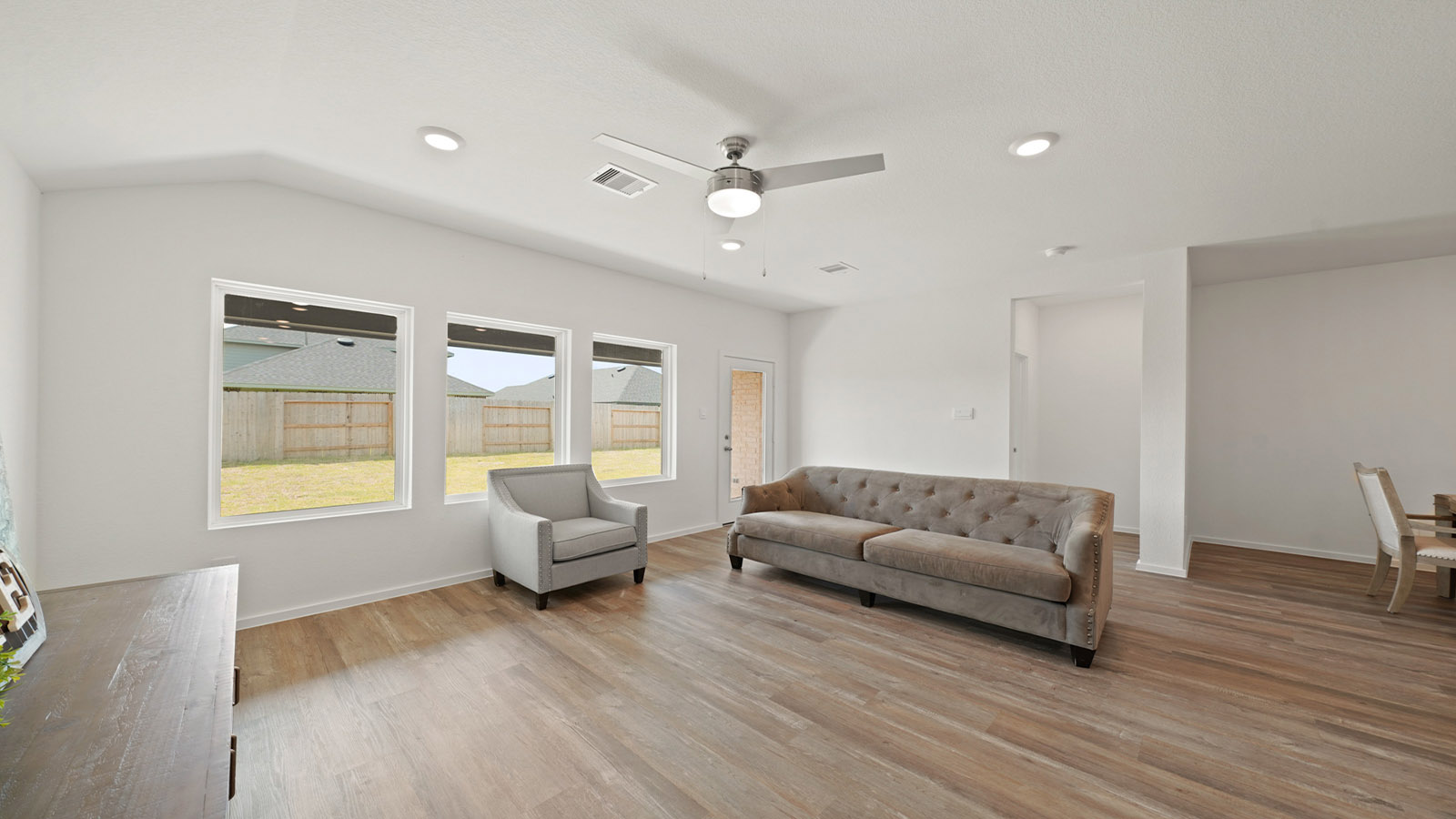 open concept living and dining area with vinyl flooring and large windows