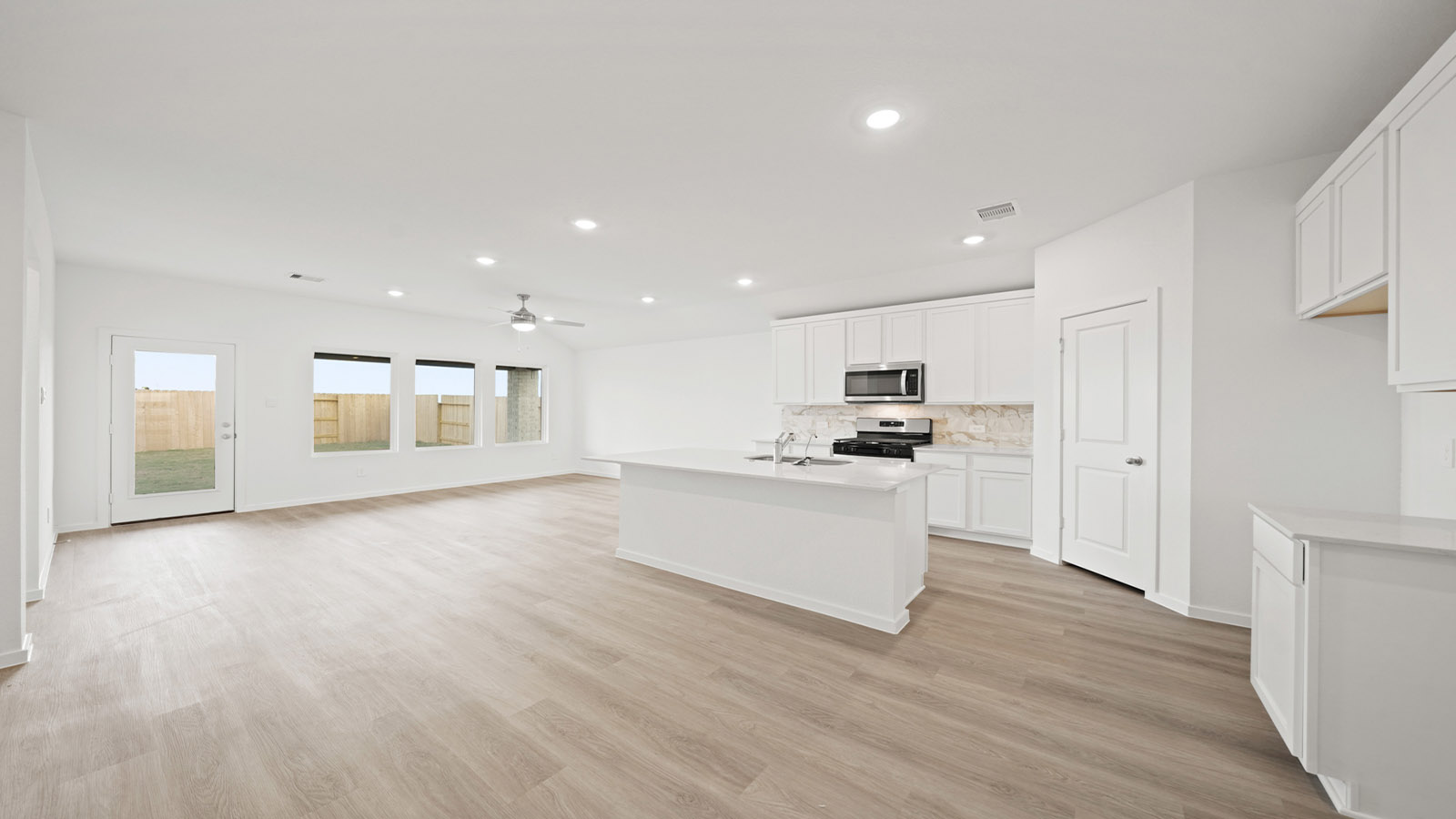 open concept living and dining area with vinyl flooring and large windows