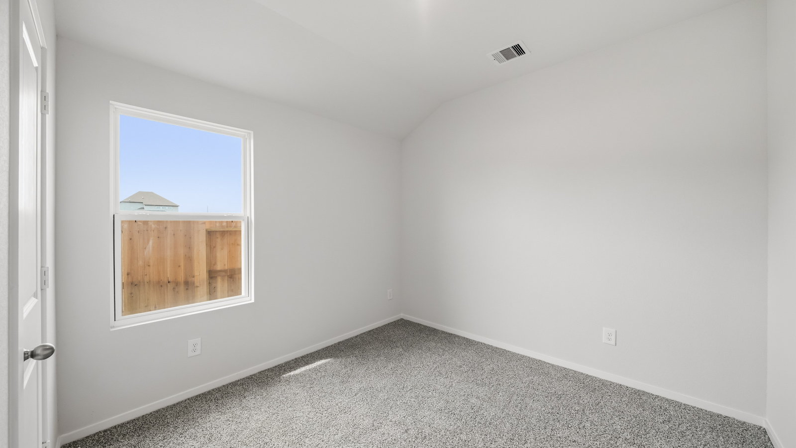 Secondary bedroom with shag carpet flooring and bright window
