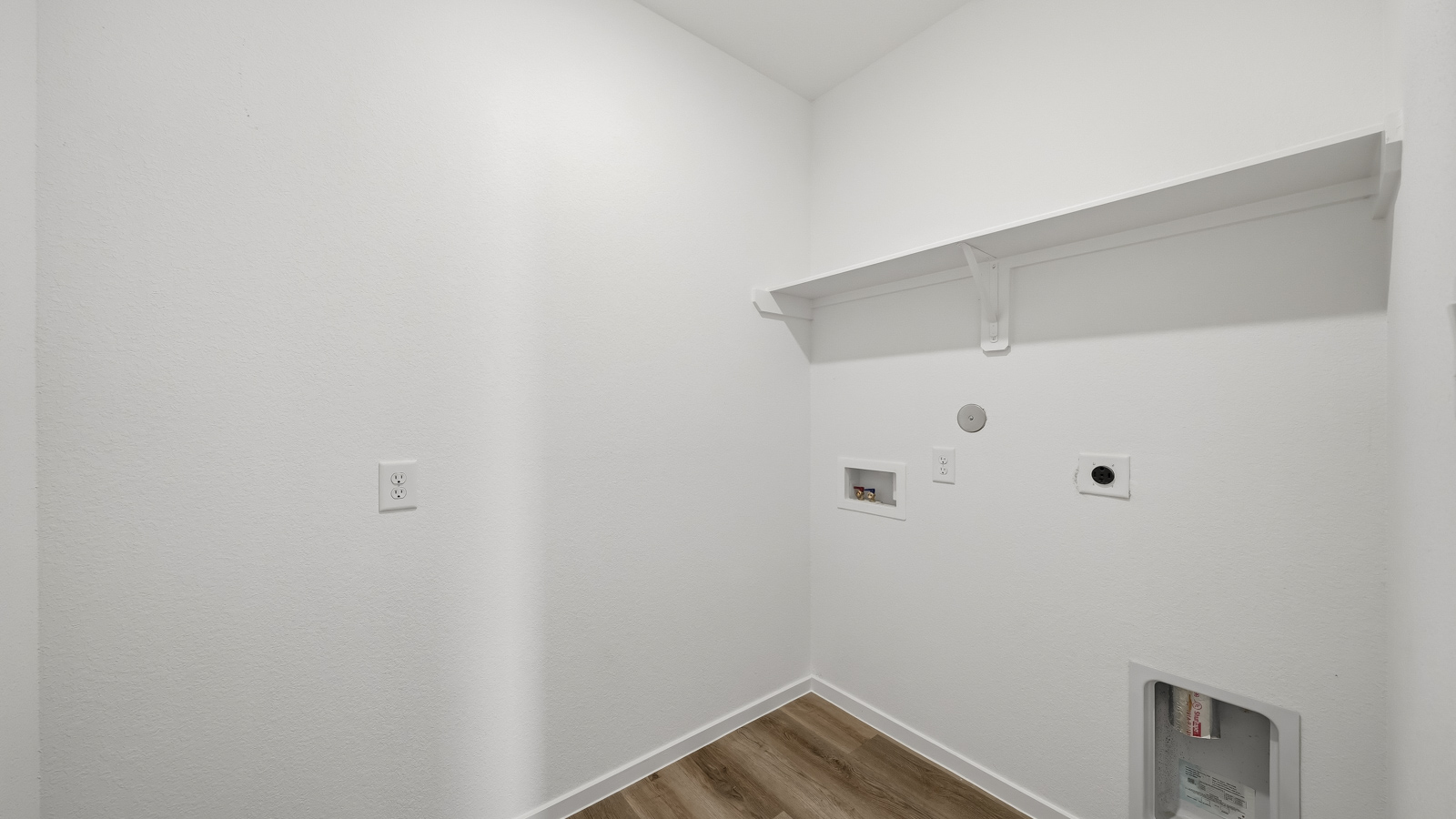 Utility room with storage located off the entry hallway and garage door