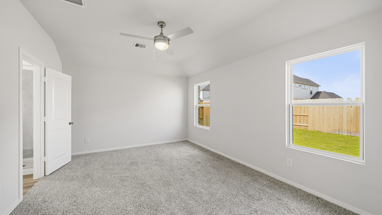 Large Primary bedroom with shag carpet flooring and bright window