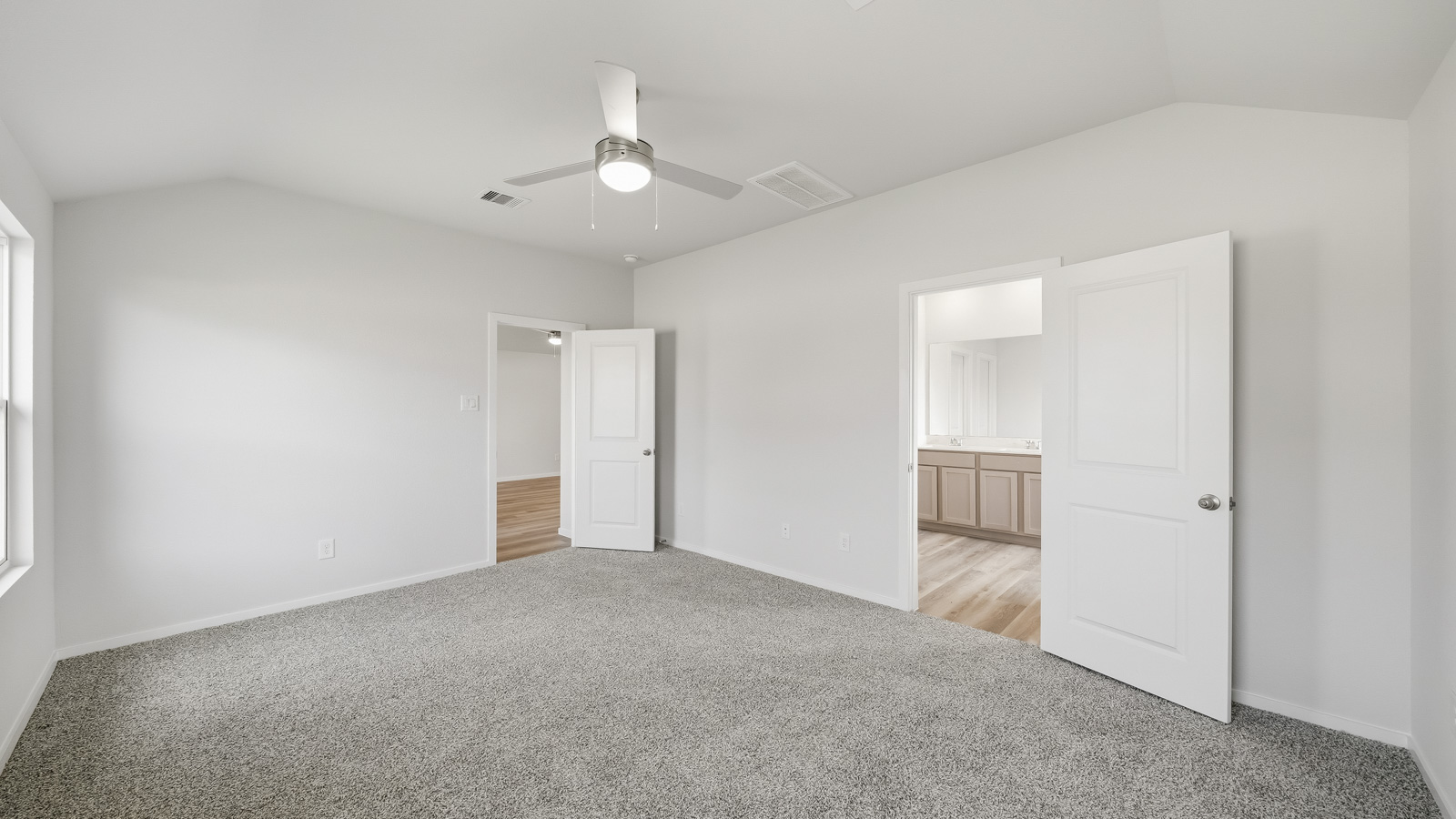 Large Primary bedroom with shag carpet flooring and bright window