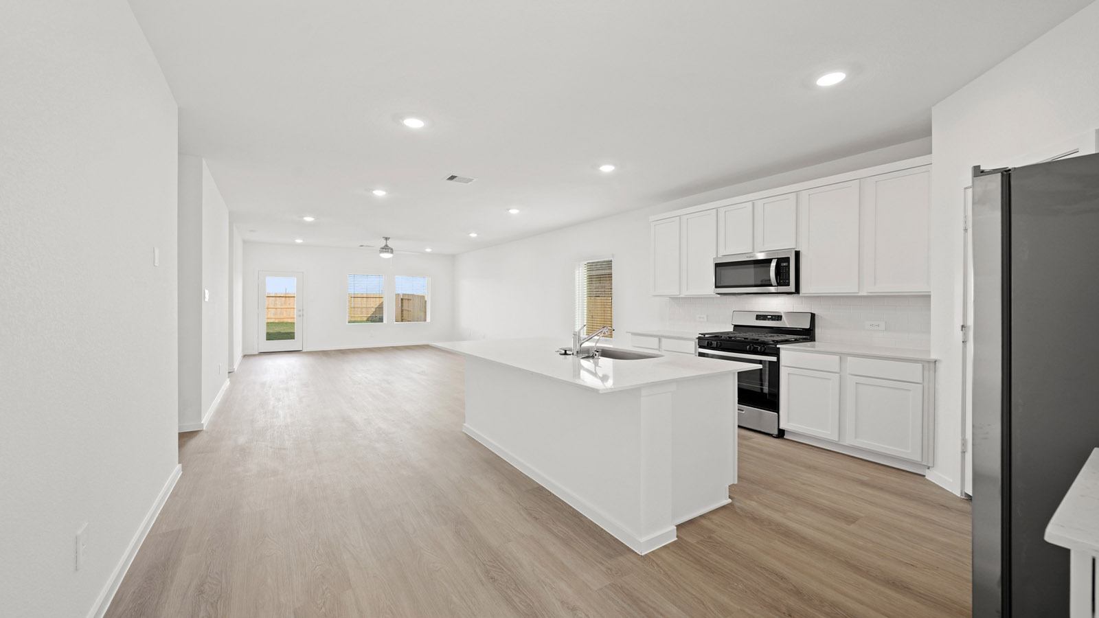 open concept living and dining area with quartz countertops and large windows