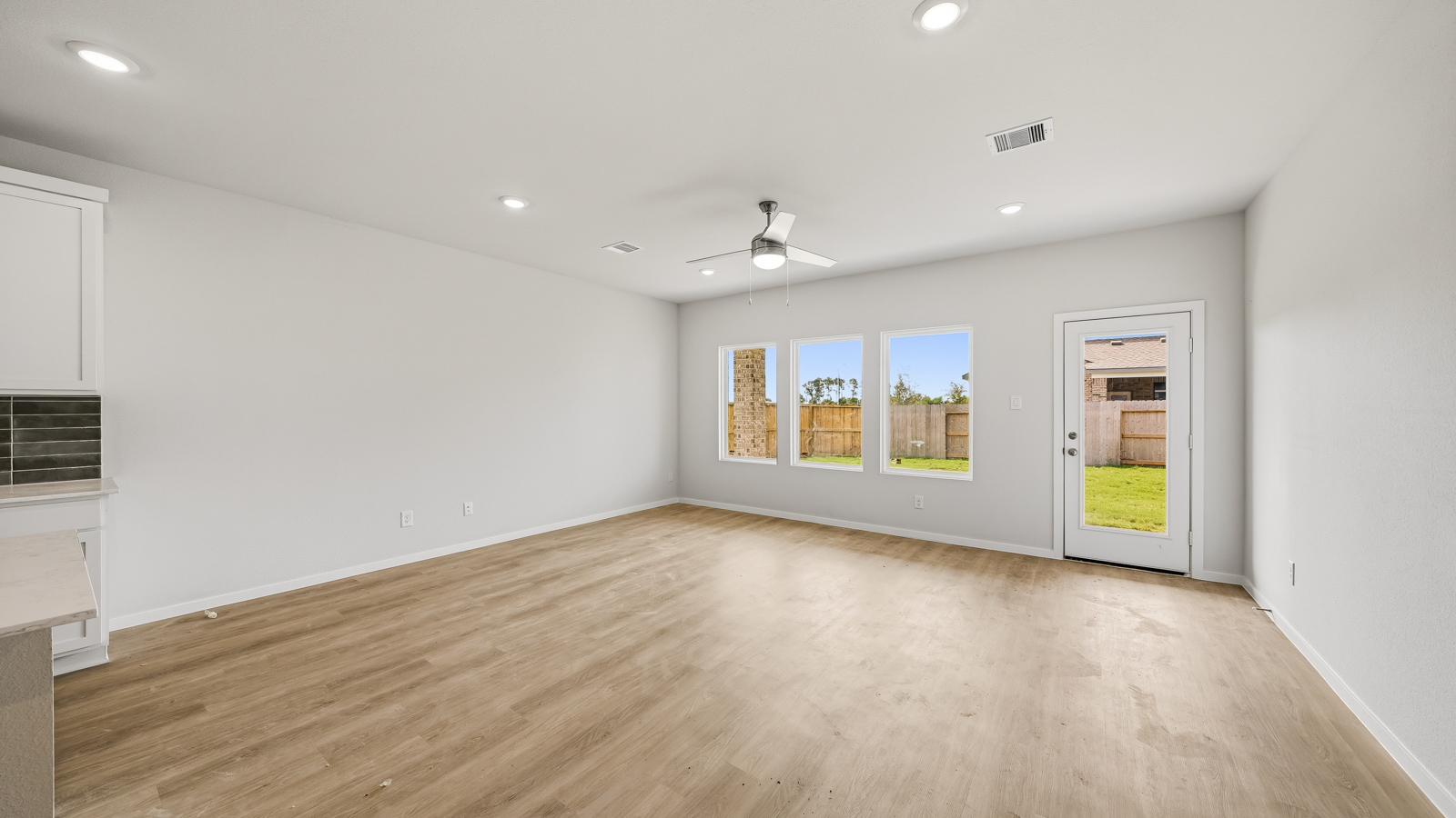 open concept living and dining area with vinyl flooring and large windows