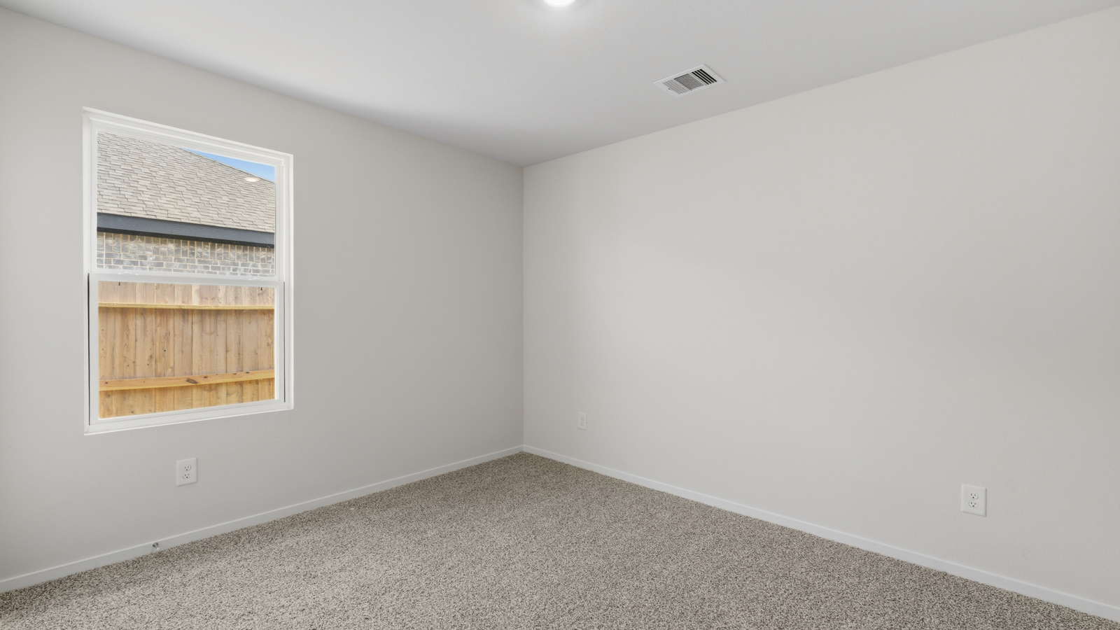Secondary bedroom with shag carpet flooring and bright window