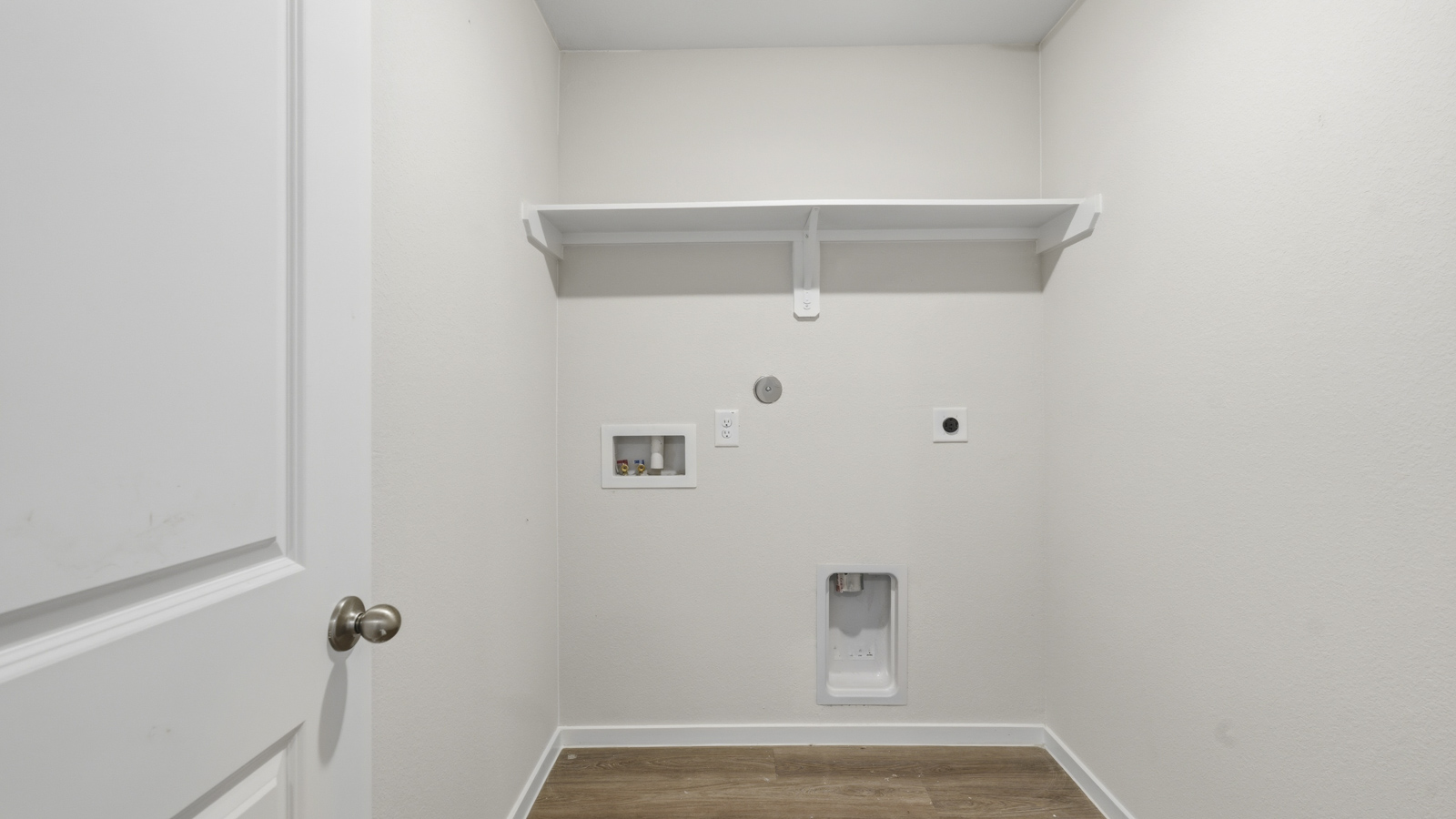 Utility room with storage located off the entry hallway and garage door