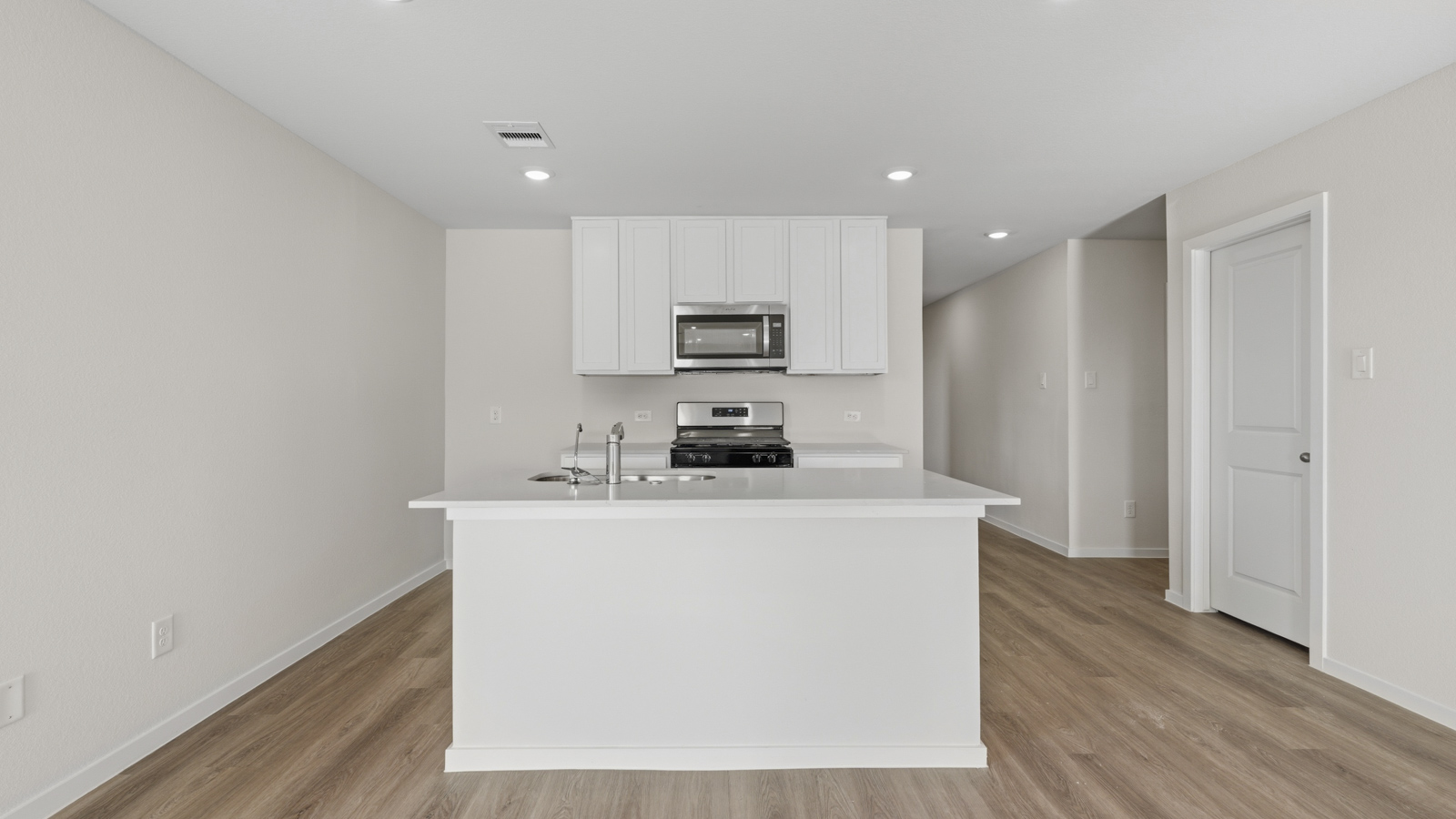 Kitchen with quartz countertops and an island and vinyl floor