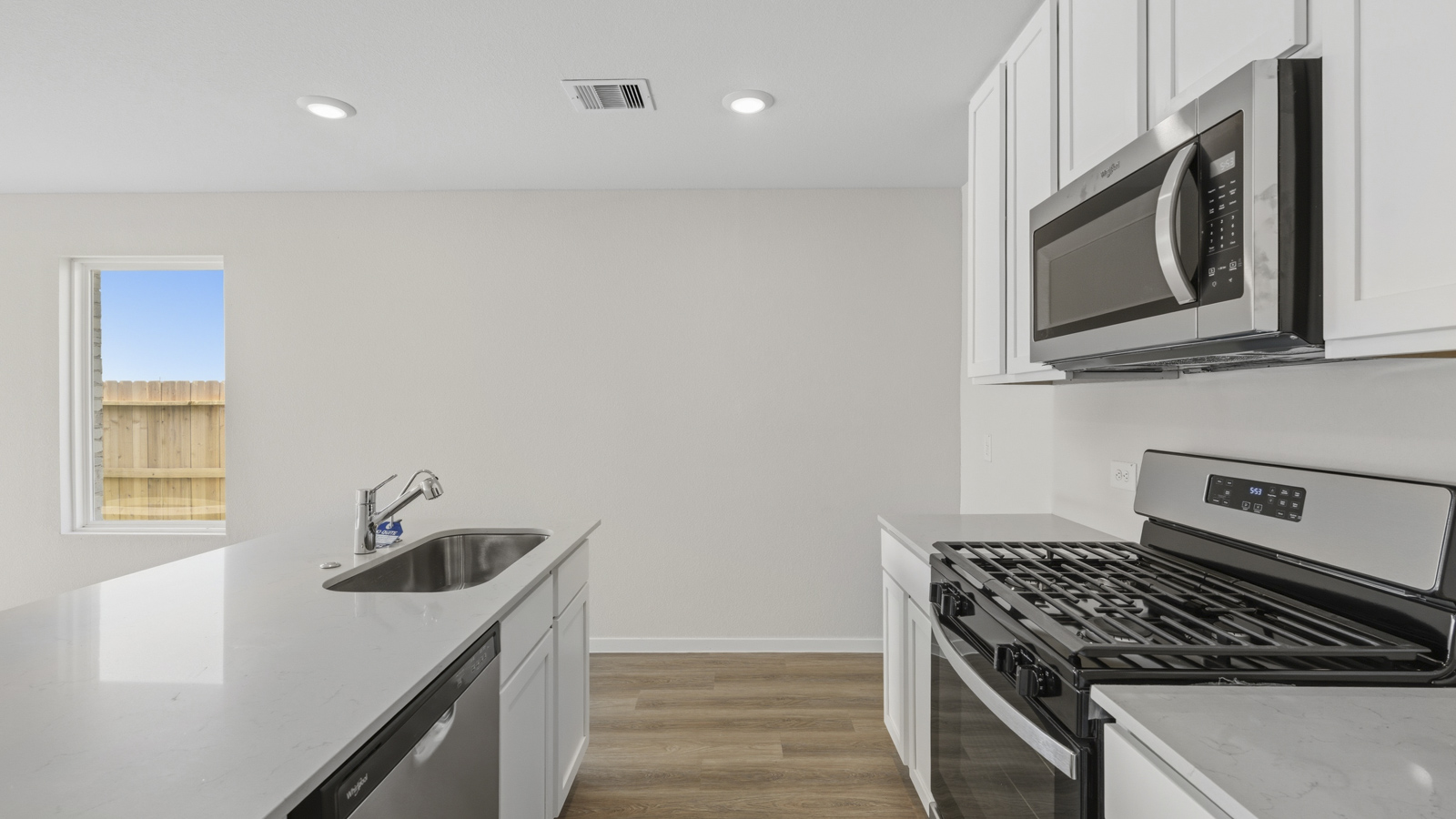 Kitchen with quartz countertops and an island and vinyl floor