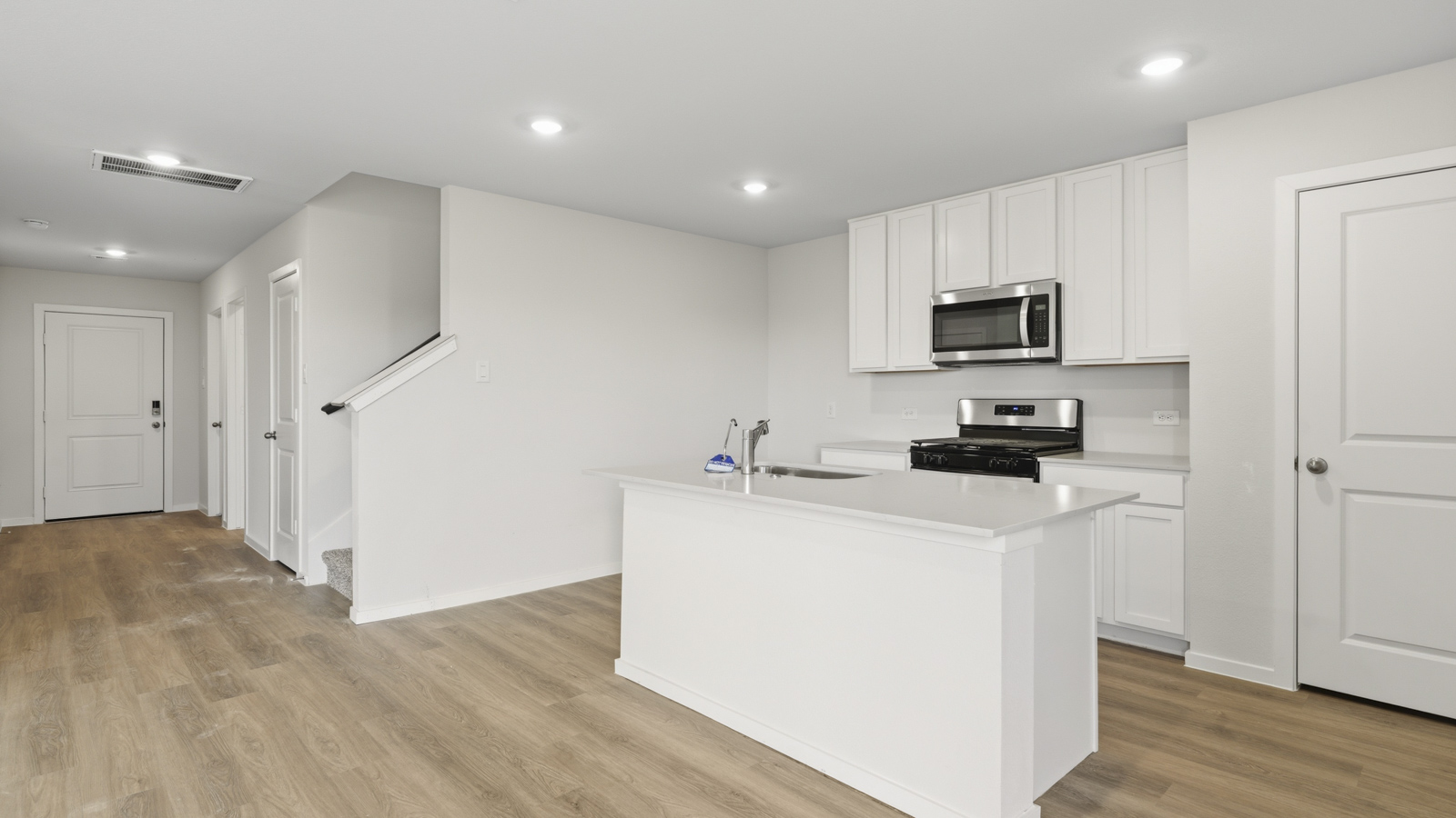 Kitchen with quartz countertops and an island and vinyl floor