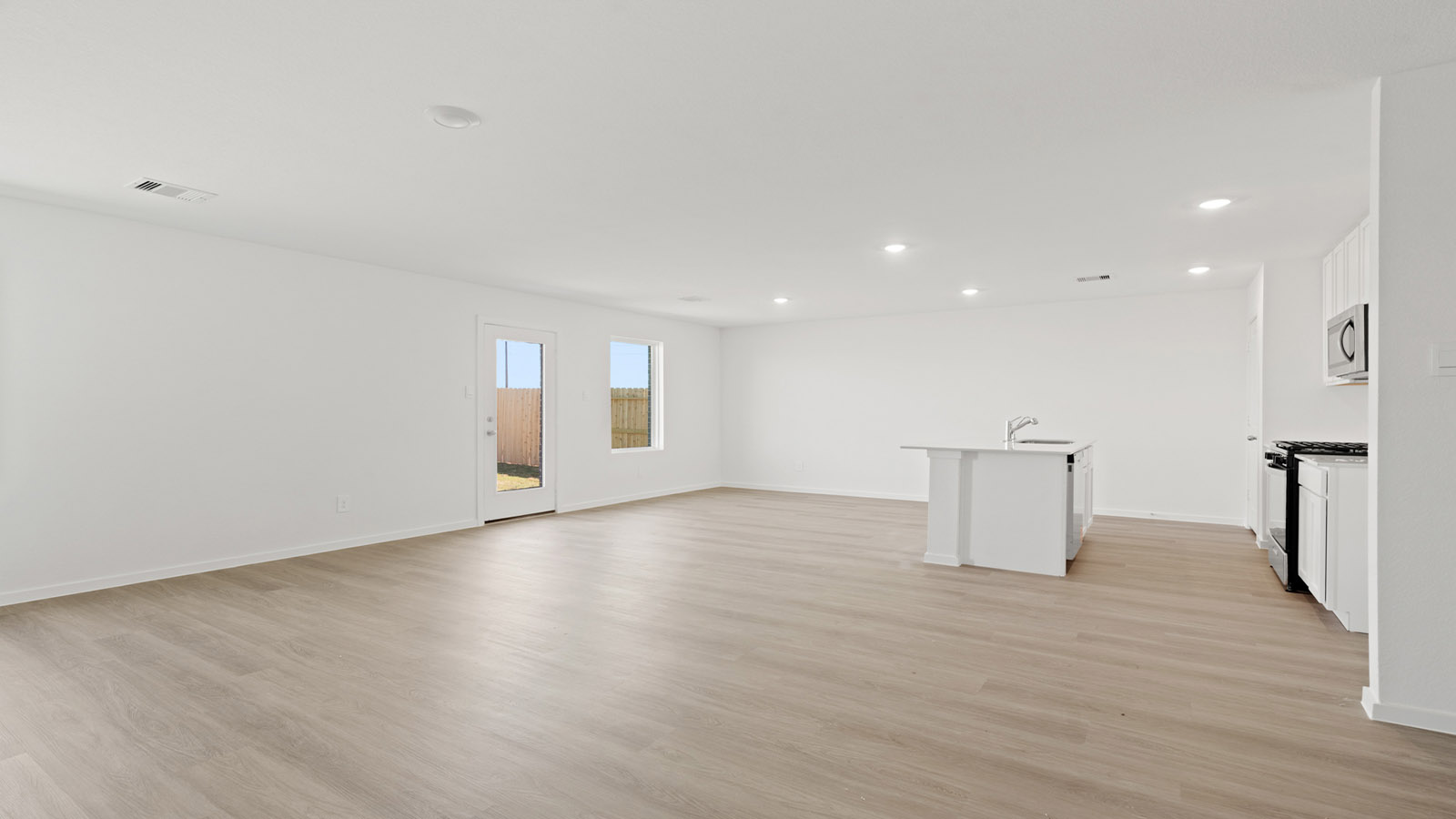 open concept living and dining area with vinyl flooring, quartz countertops, and large windows