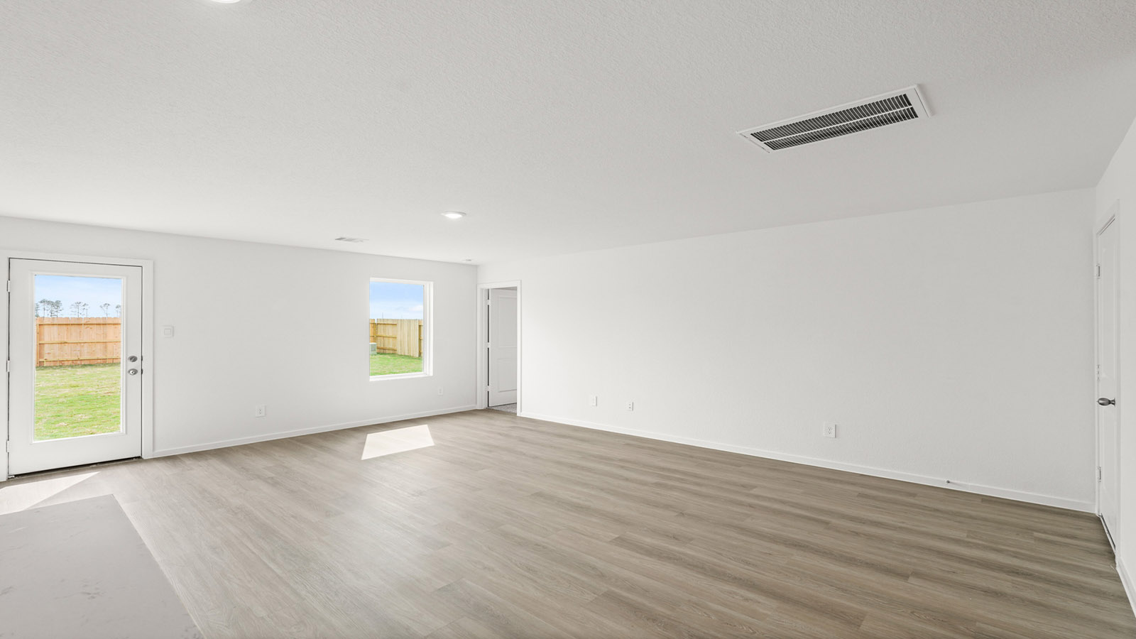 Spacious living area with vinyl flooring