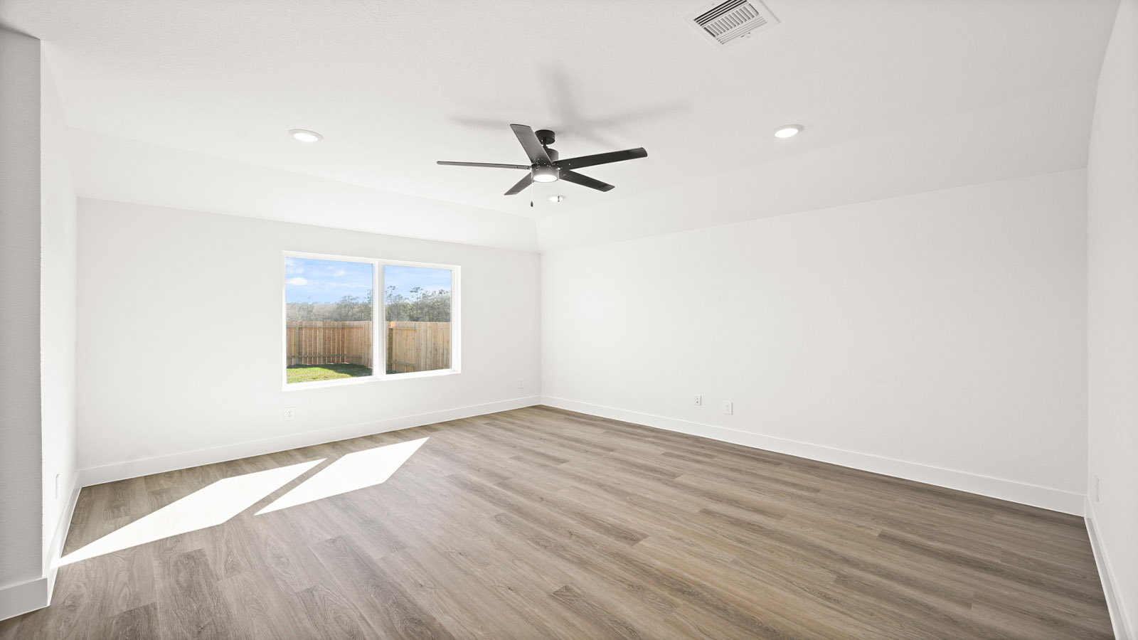 Spacious living area with vinyl flooring