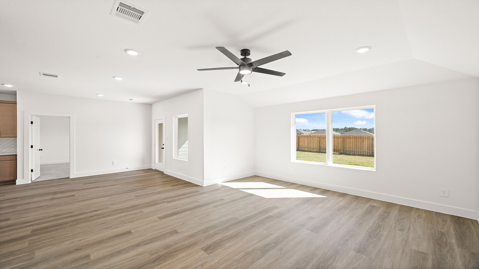 Spacious living area with vinyl flooring