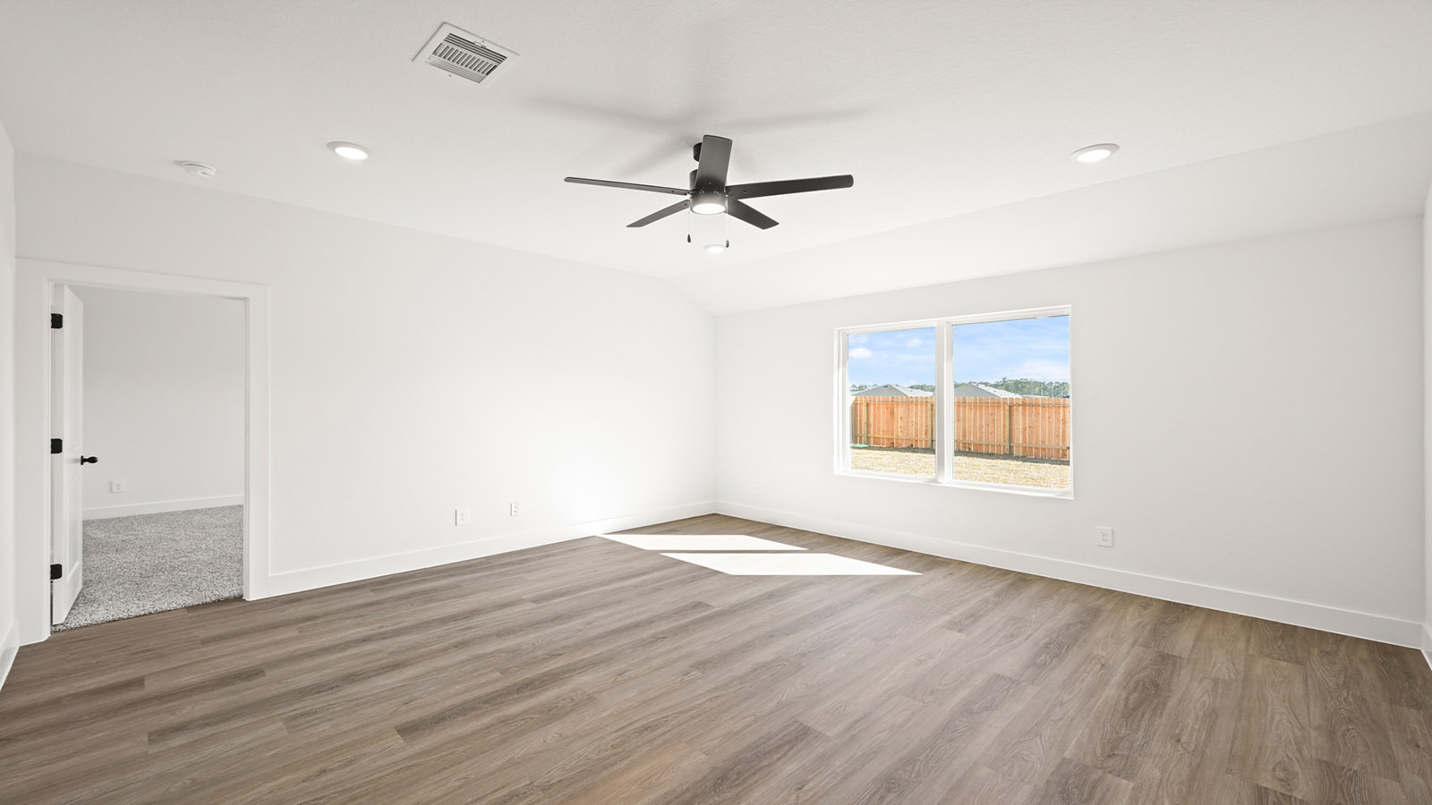 Spacious living area with vinyl flooring