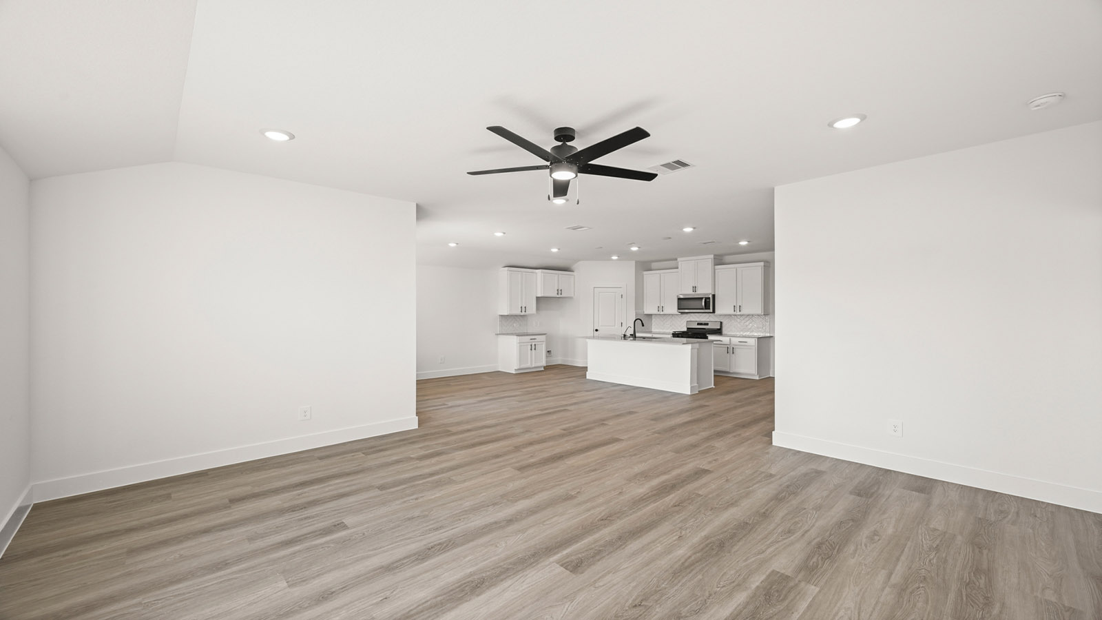 Spacious living area with vinyl flooring