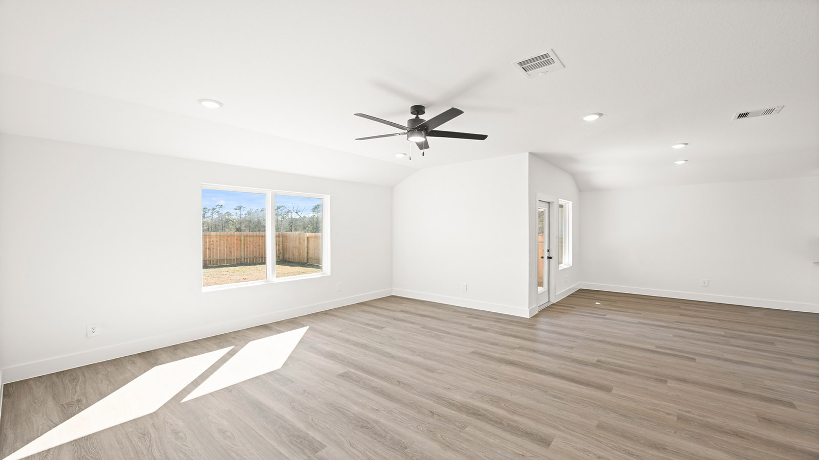 Spacious living area with vinyl flooring
