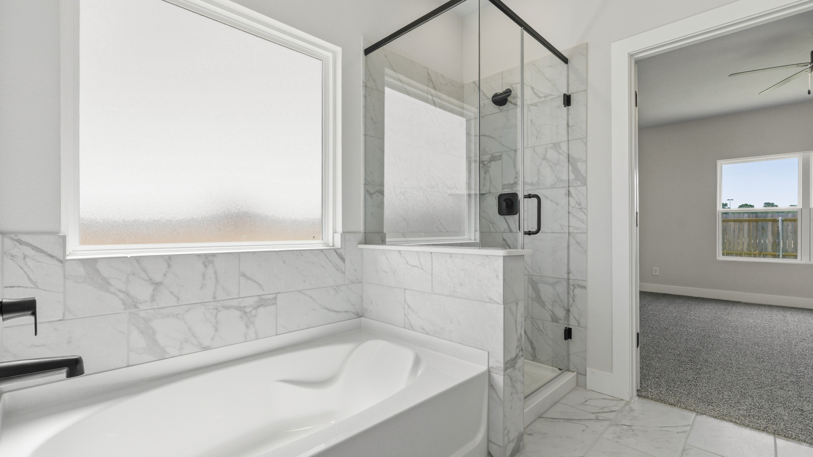 Primary bathroom with soaker tub and tile shower with semi frameless glass in Montgomery TX