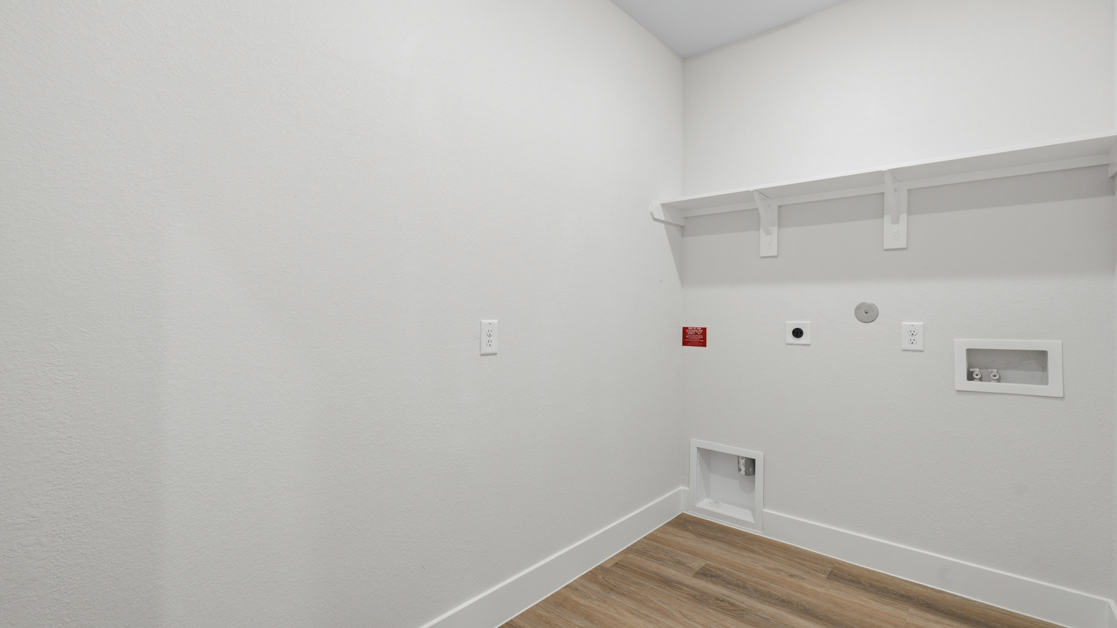 Utility room with storage located off the entry hallway and garage door