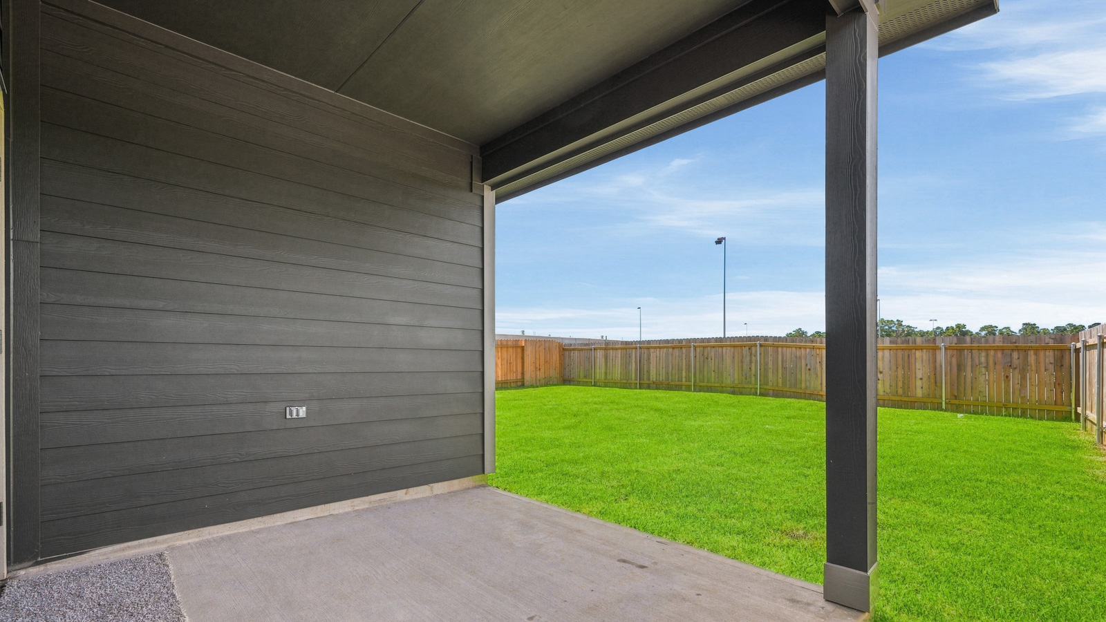 covered patio with jamies hardie siding and overhead lighting