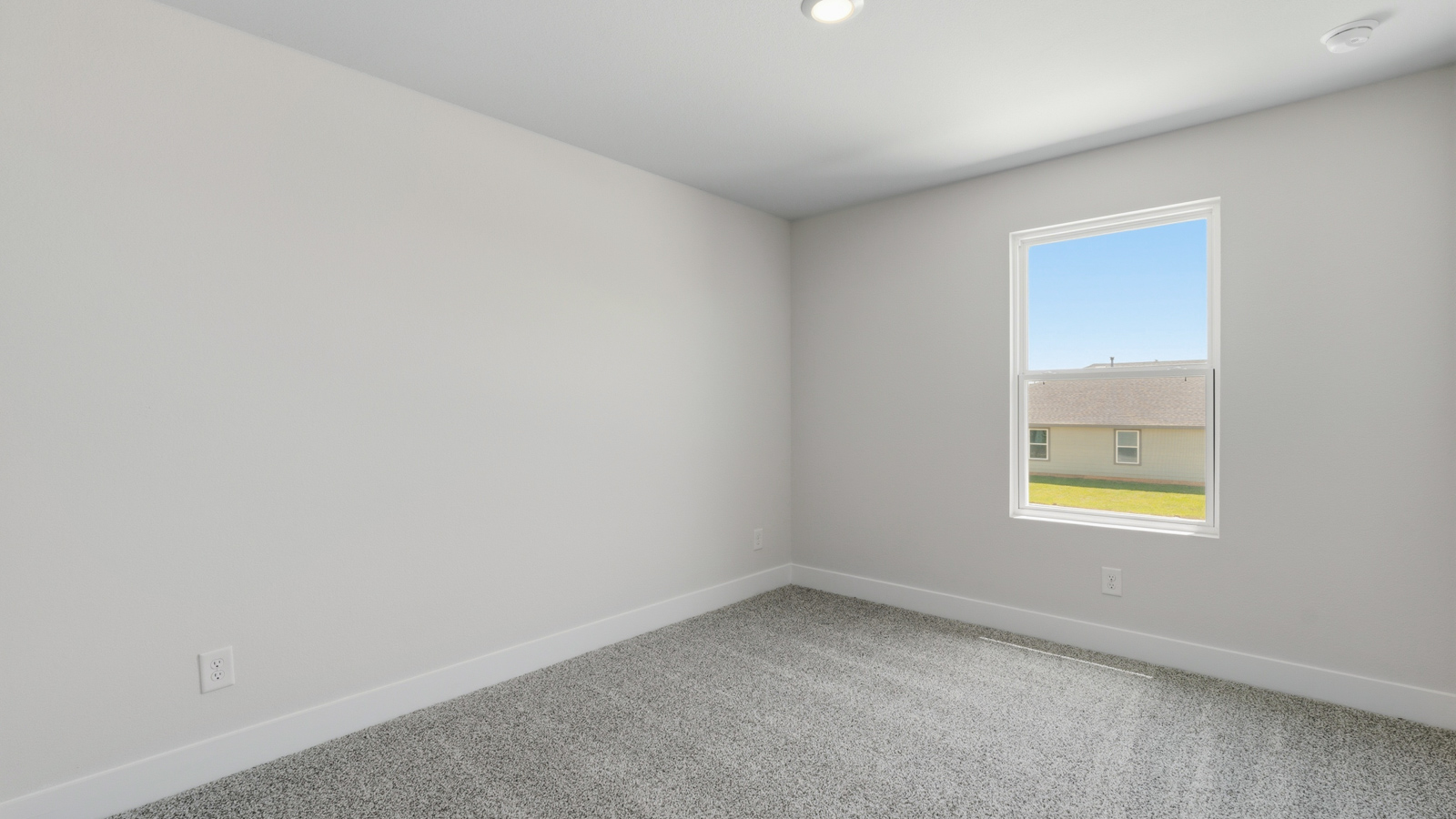 Second level secondary bedroom with carpet flooring and bright window