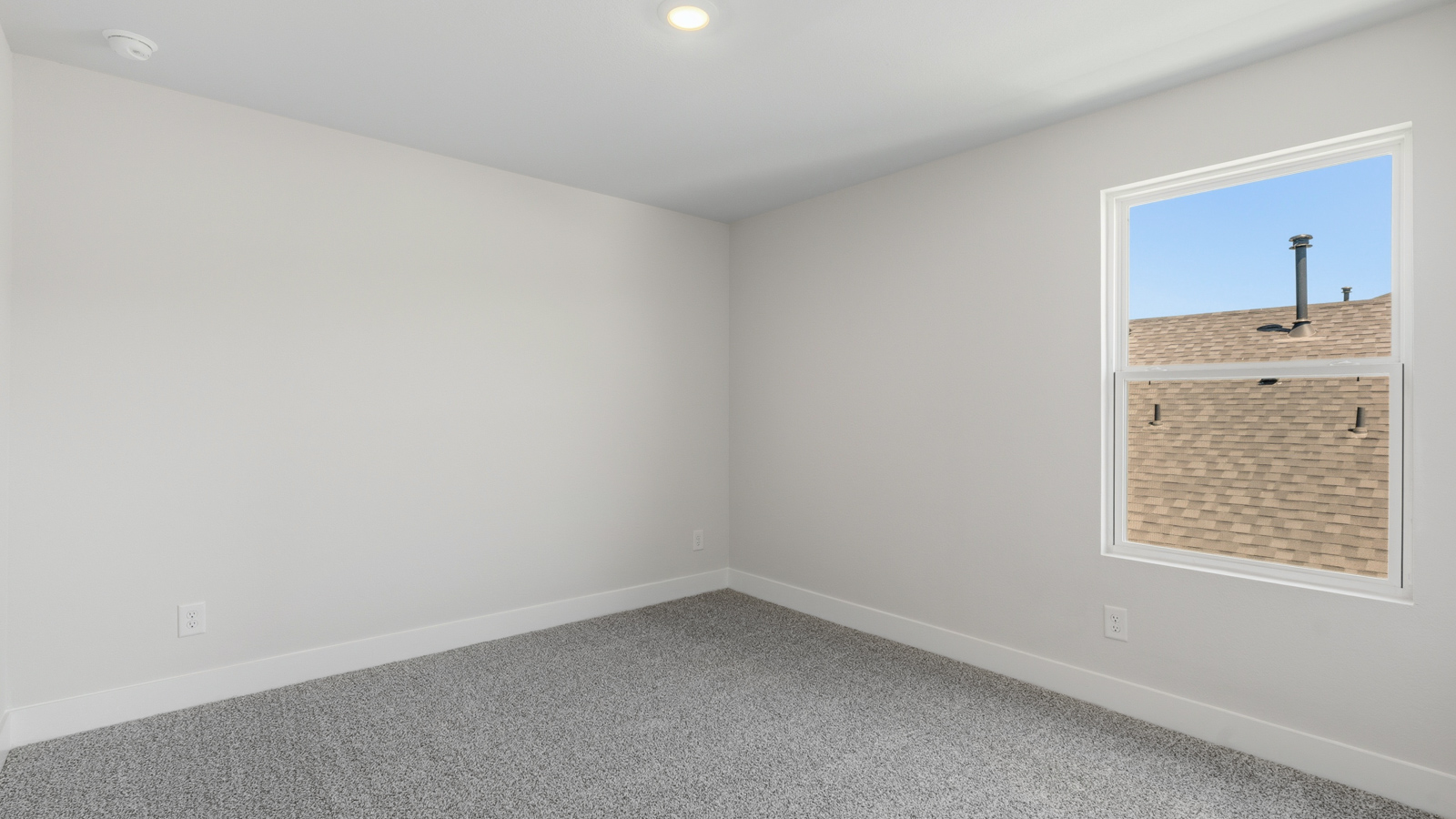 Second level secondary bedroom with carpet flooring and bright window