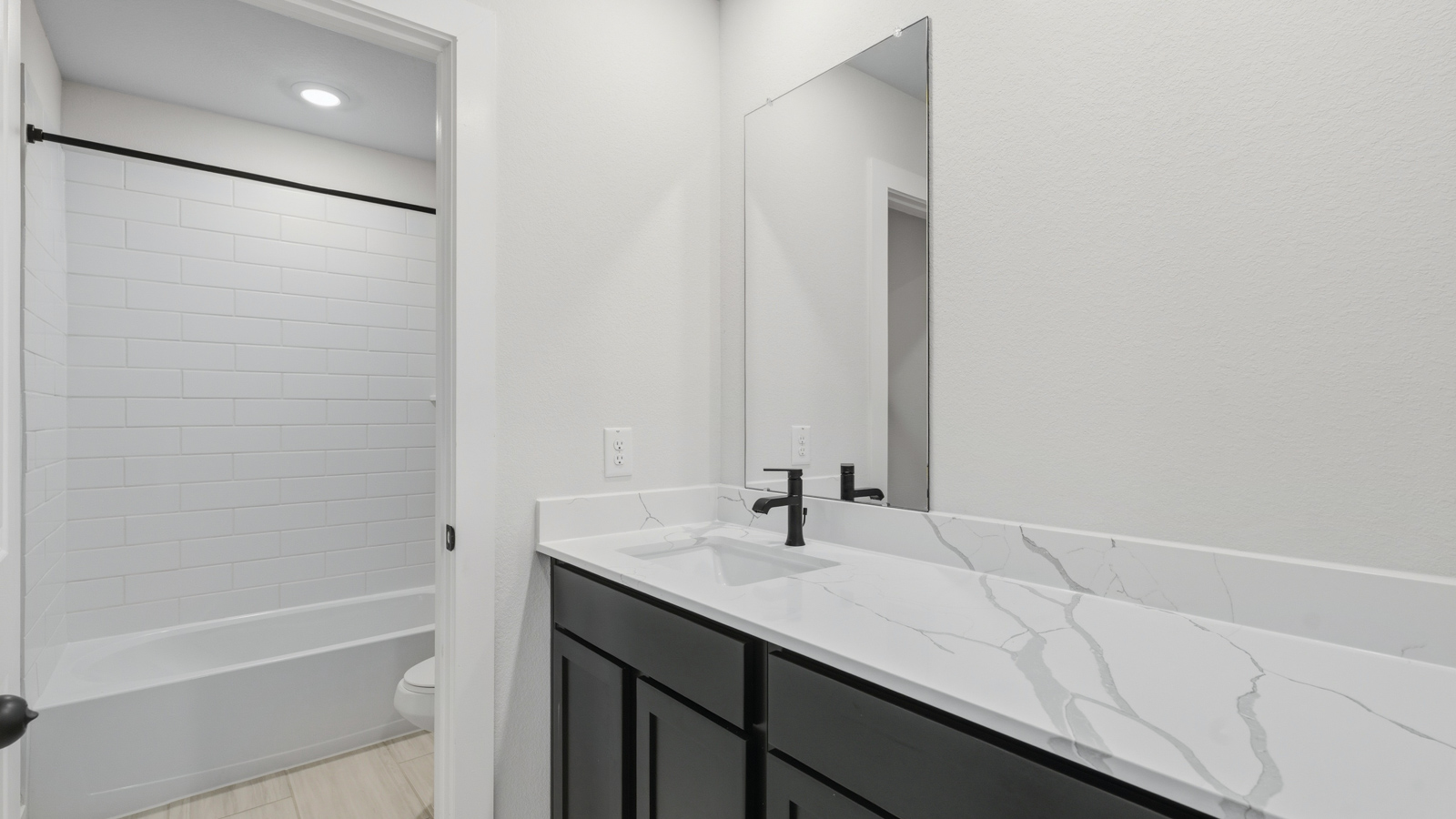 Secondary bathroom with tub/shower combo with quartz counter tops in montgomery TX