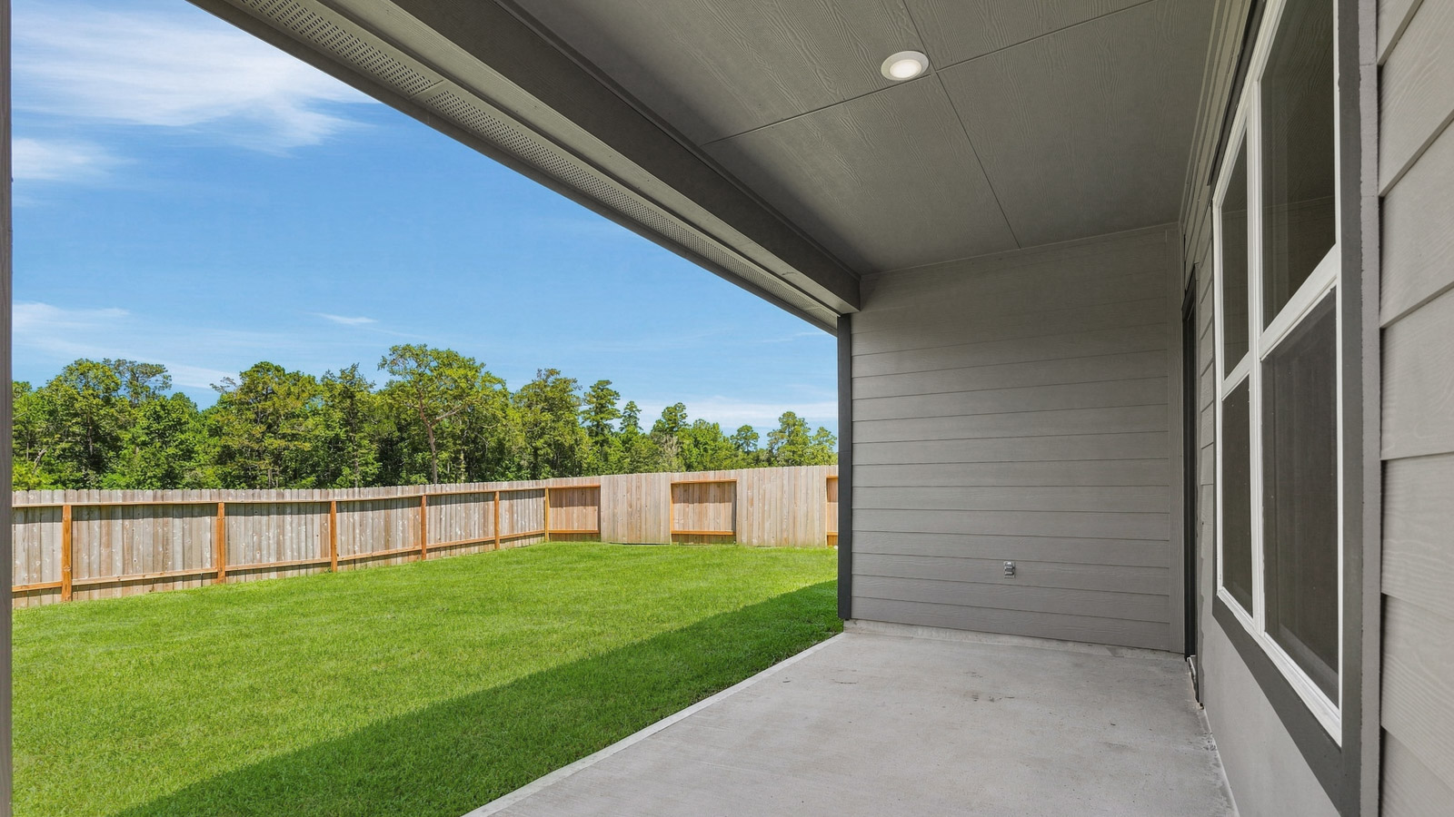 covered patio with jamies hardie siding and overhead lighting