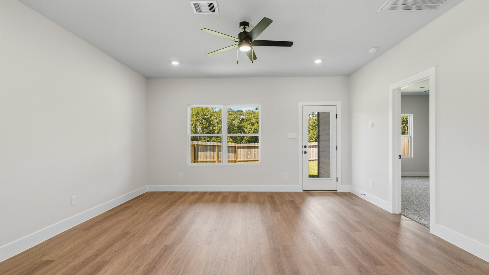 Spacious living area with vinyl flooring and bright windows in Montgomery TX
