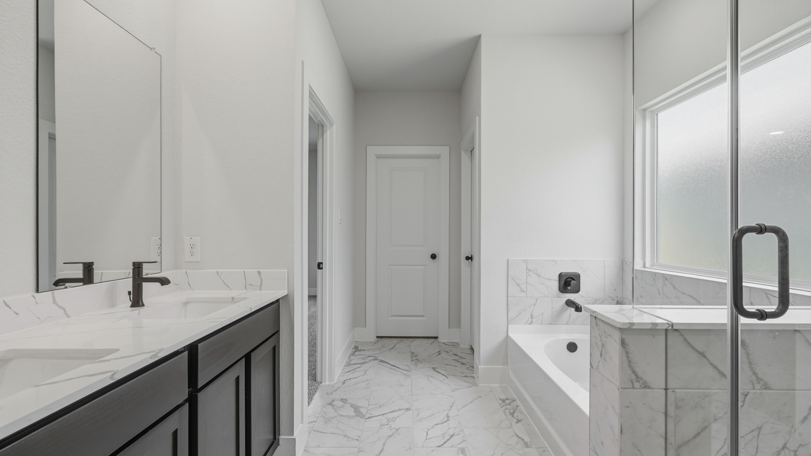 Primary bathroom with soaker tub and tile shower with semi frameless glass in Montgomery TX