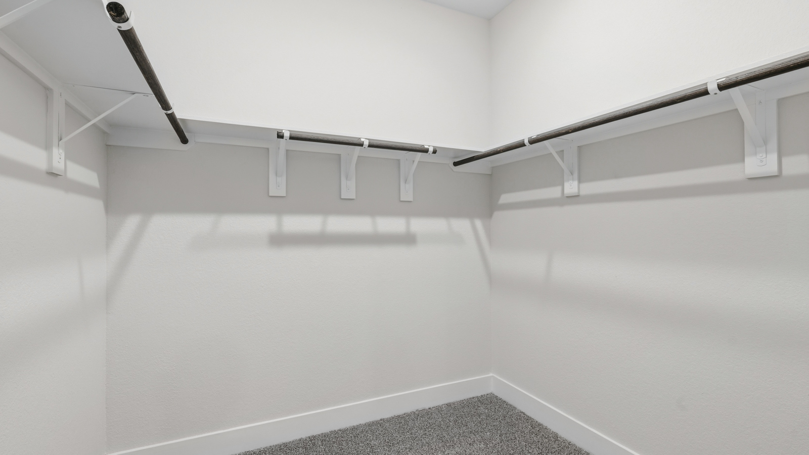 Primary bedroom walk-in closet with carpet flooring in Chapel Lakes community in Montgomery TX