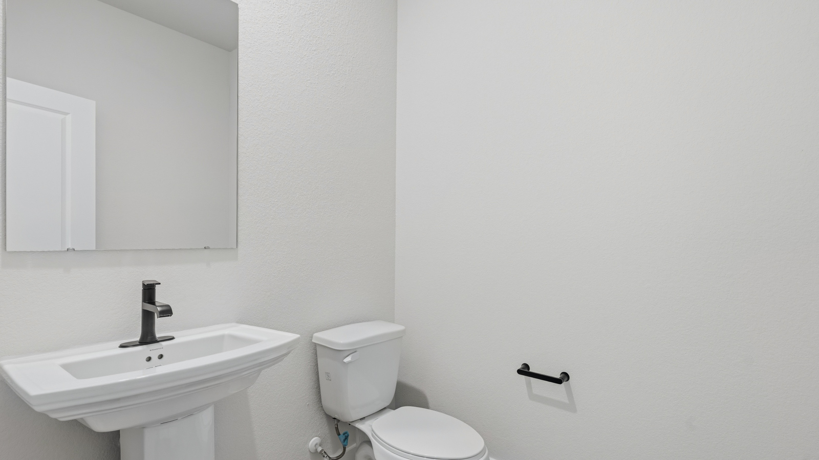 Powder bathroom with pedestal sink right off the foyer entry hallway