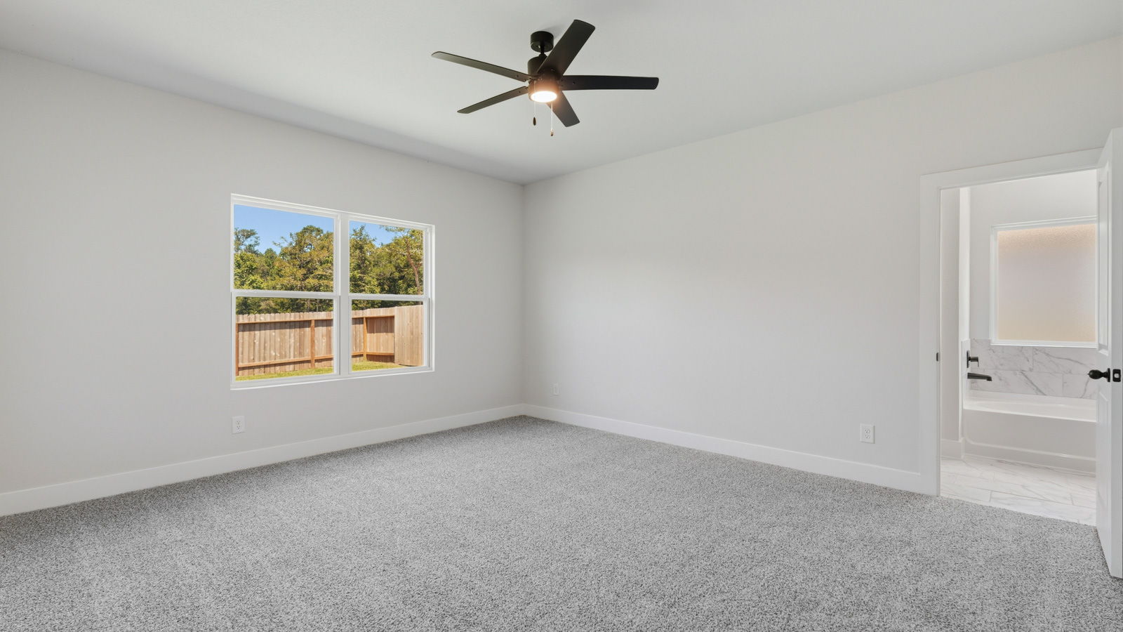 Large Primary bedroom with shag carpet flooring and bright window