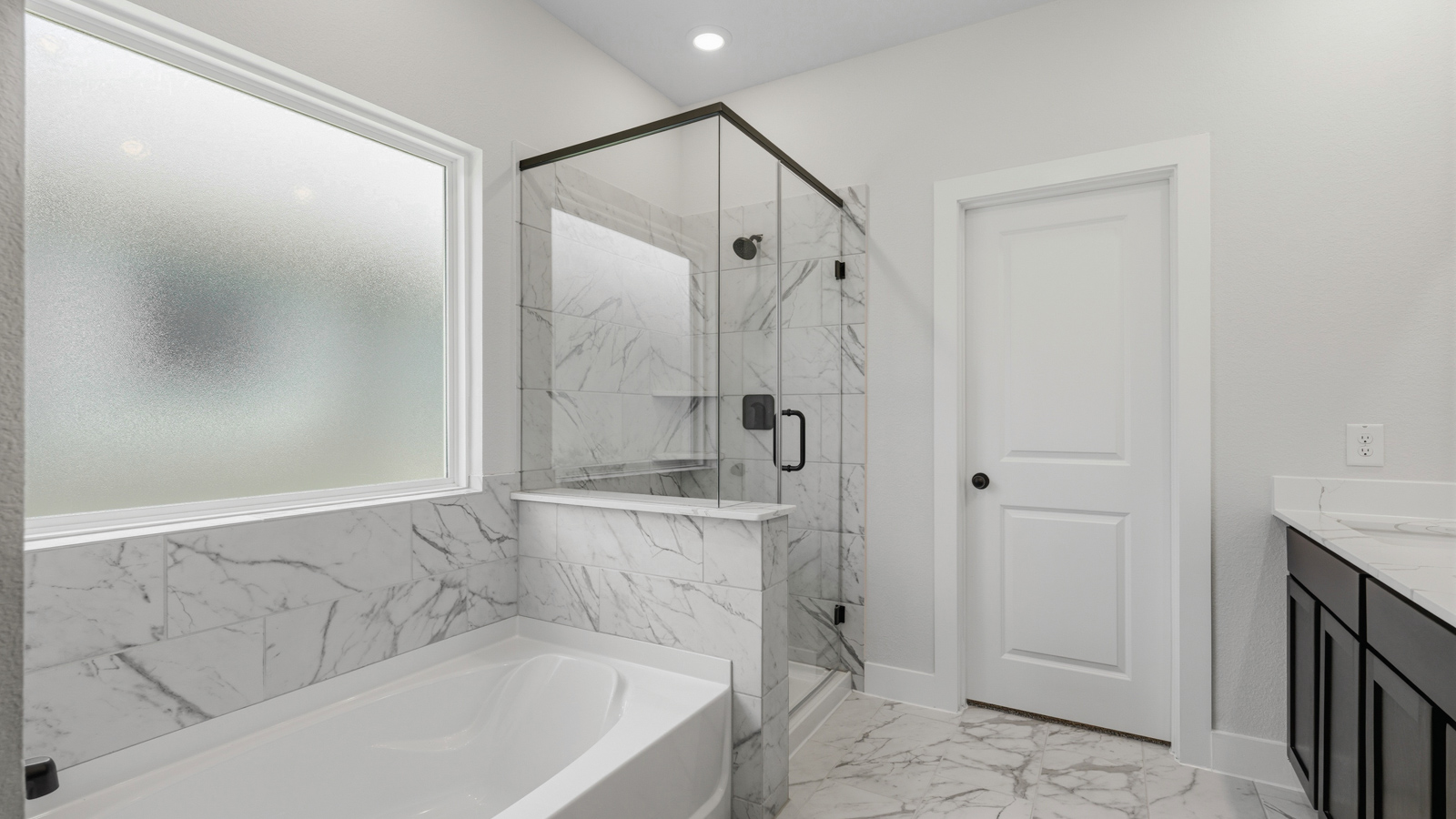 Primary bathroom with soaker tub and tile shower with semi frameless glass in Montgomery TX