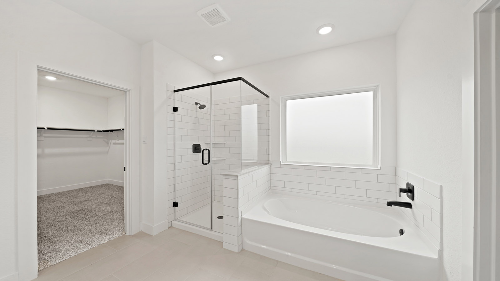 Primary bathroom with soaker tub and tile shower with semi frameless glass in Montgomery TX