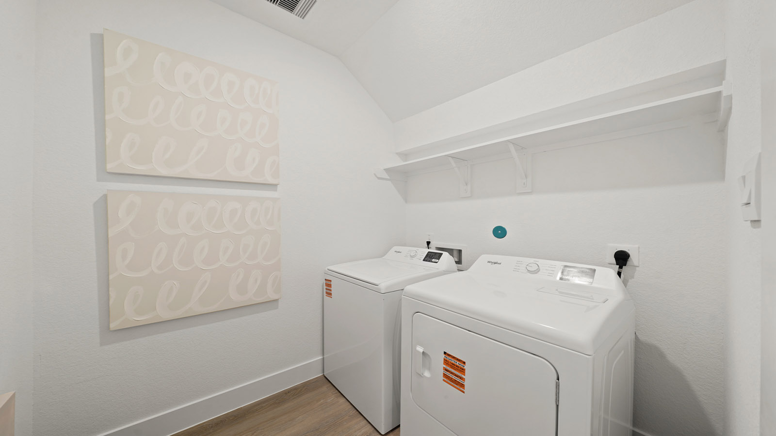 Utility room with storage located off the entry hallway and garage door